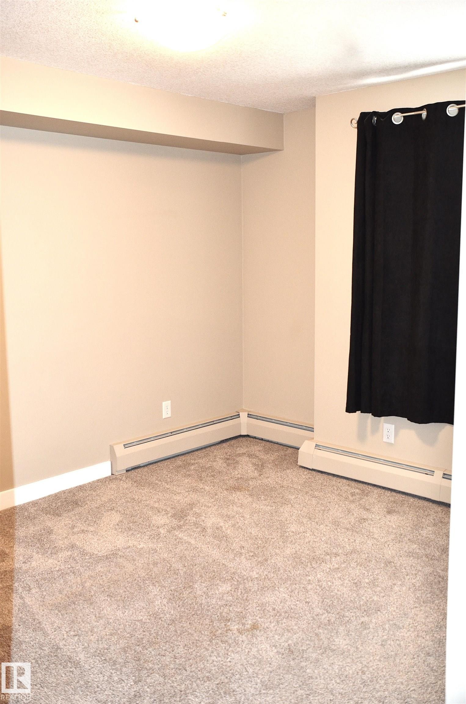 Neutral-toned carpet flooring complementing beige wall paint - 103 920 156 Street Nw, Edmonton, AB - Indoor Photo Showing Other Room