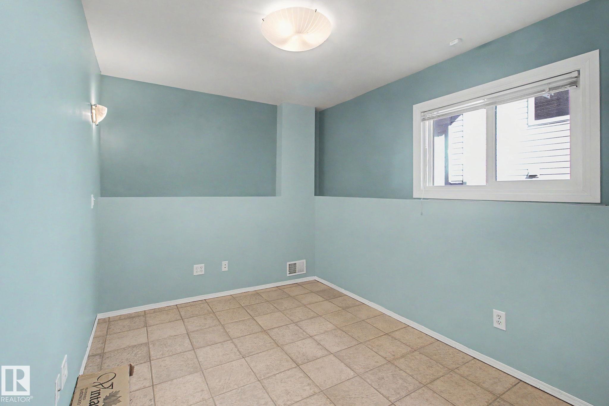 Room featuring light blue walls, tan tile flooring, and a white baseboard trim - 3903 32 Street, Edmonton, AB - Indoor Photo Showing Other Room
