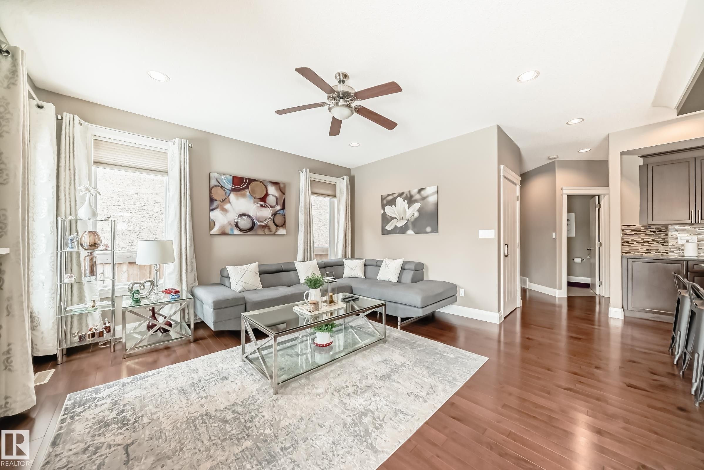 This inviting living area features hardwood floors, recessed lighting, and a ceiling fan - 3220 151 Avenue, Edmonton, AB - Indoor Photo Showing Living Room
