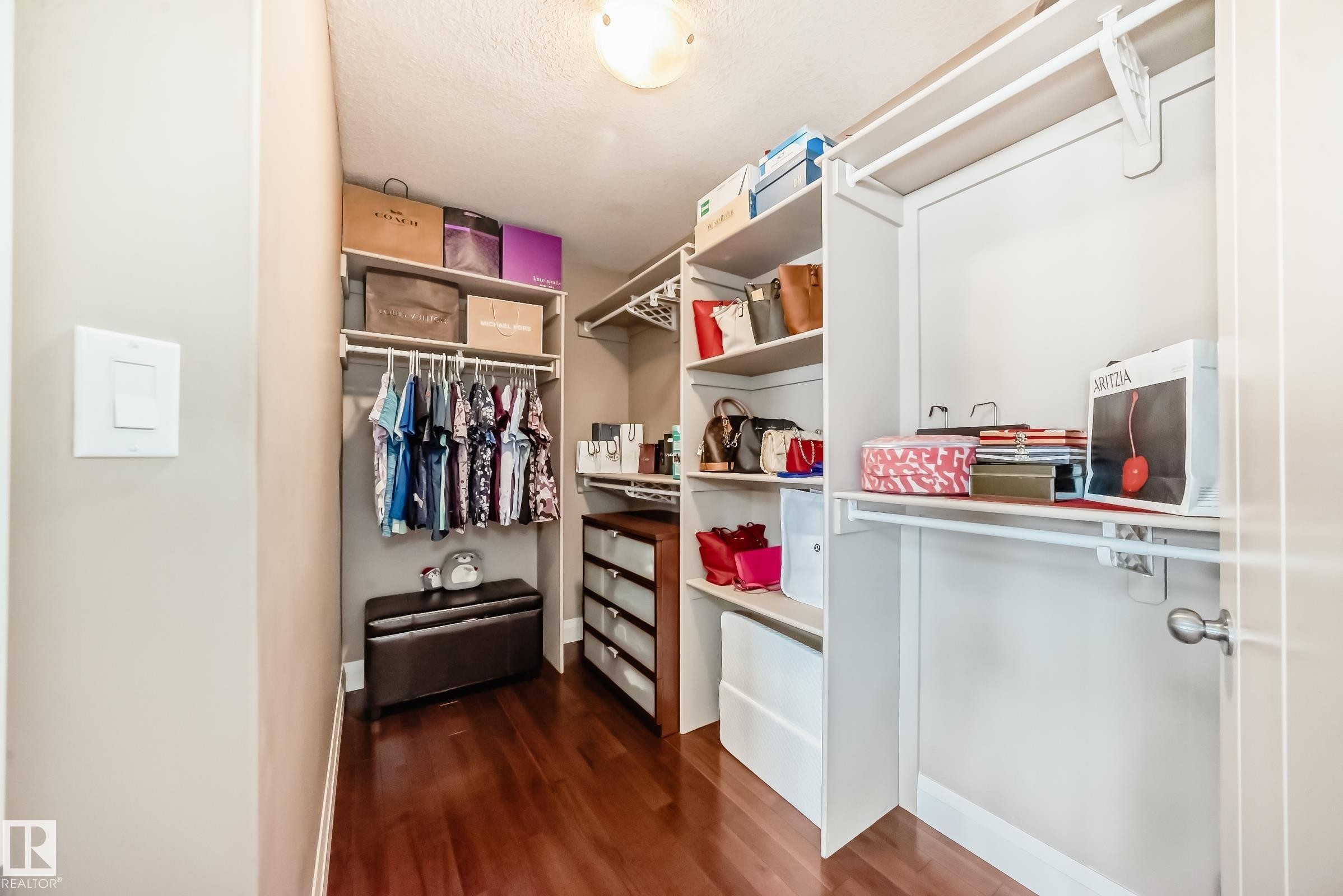 The property features a closet with rich hardwood flooring, built-in shelving, and hanging rods for ample storage - 3220 151 Avenue, Edmonton, AB - Indoor With Storage