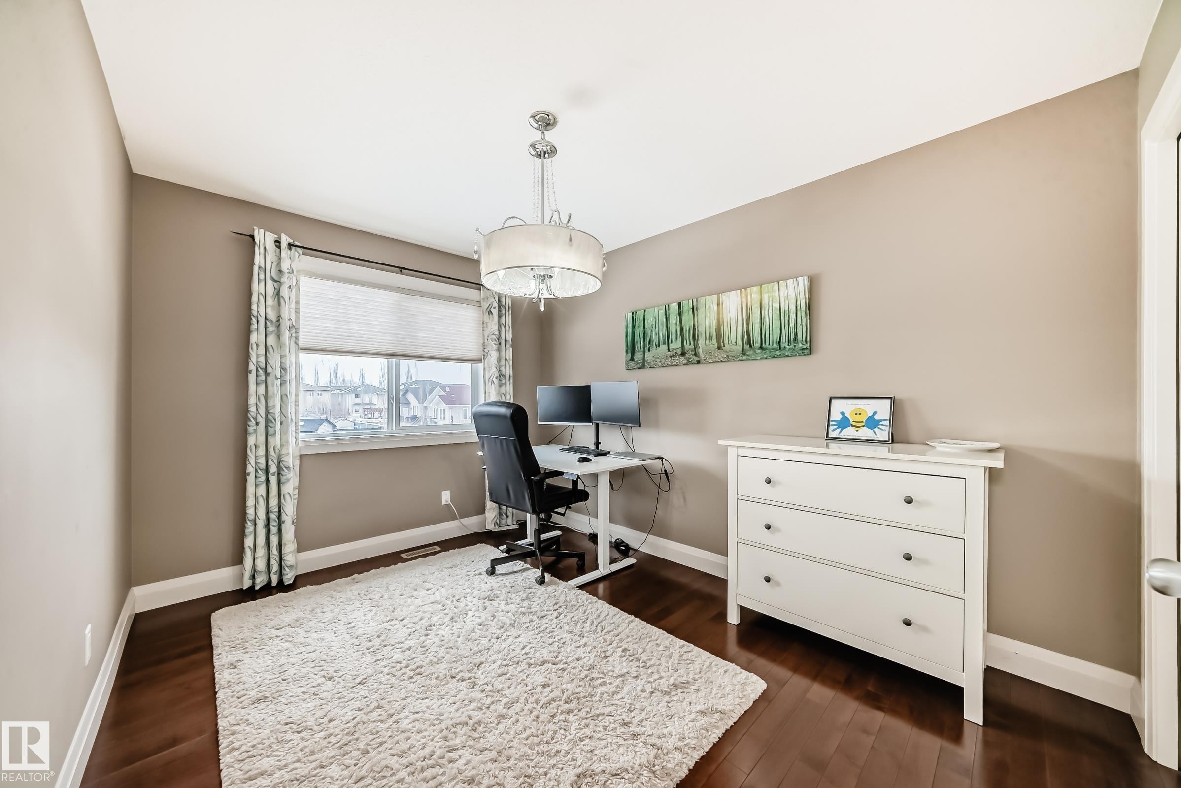 This versatile room features hardwood floors, a large window with blinds and patterned curtains, and a contemporary chandelier - 3220 151 Avenue, Edmonton, AB - Indoor Photo Showing Office