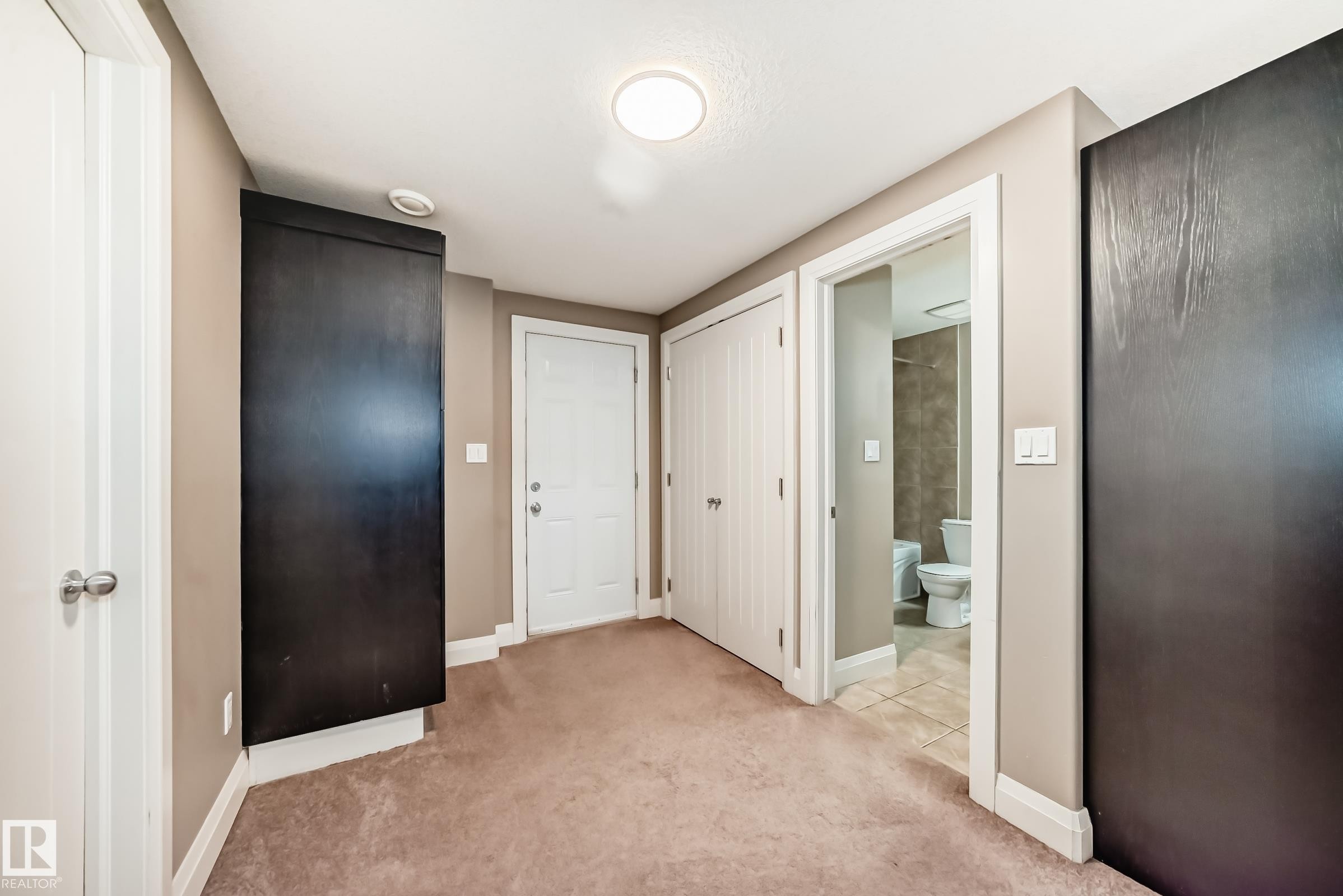 This interior space features light brown walls, a ceiling-mounted light fixture, and a light brown carpet - 3220 151 Avenue, Edmonton, AB - Indoor Photo Showing Other Room