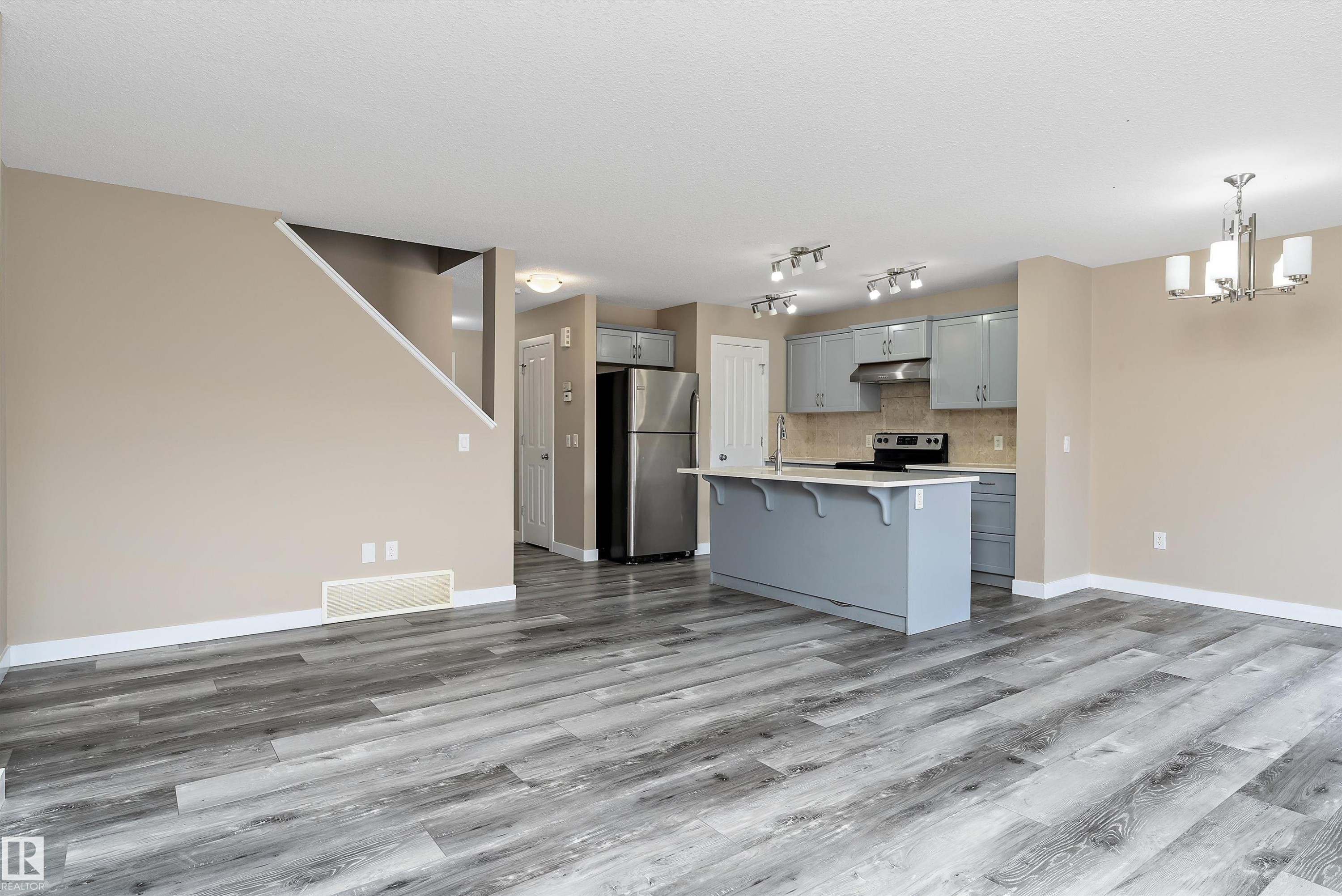 Spacious open-concept living area featuring wood-finish flooring - 3314 9 Street Nw, Edmonton, AB - Indoor Photo Showing Kitchen