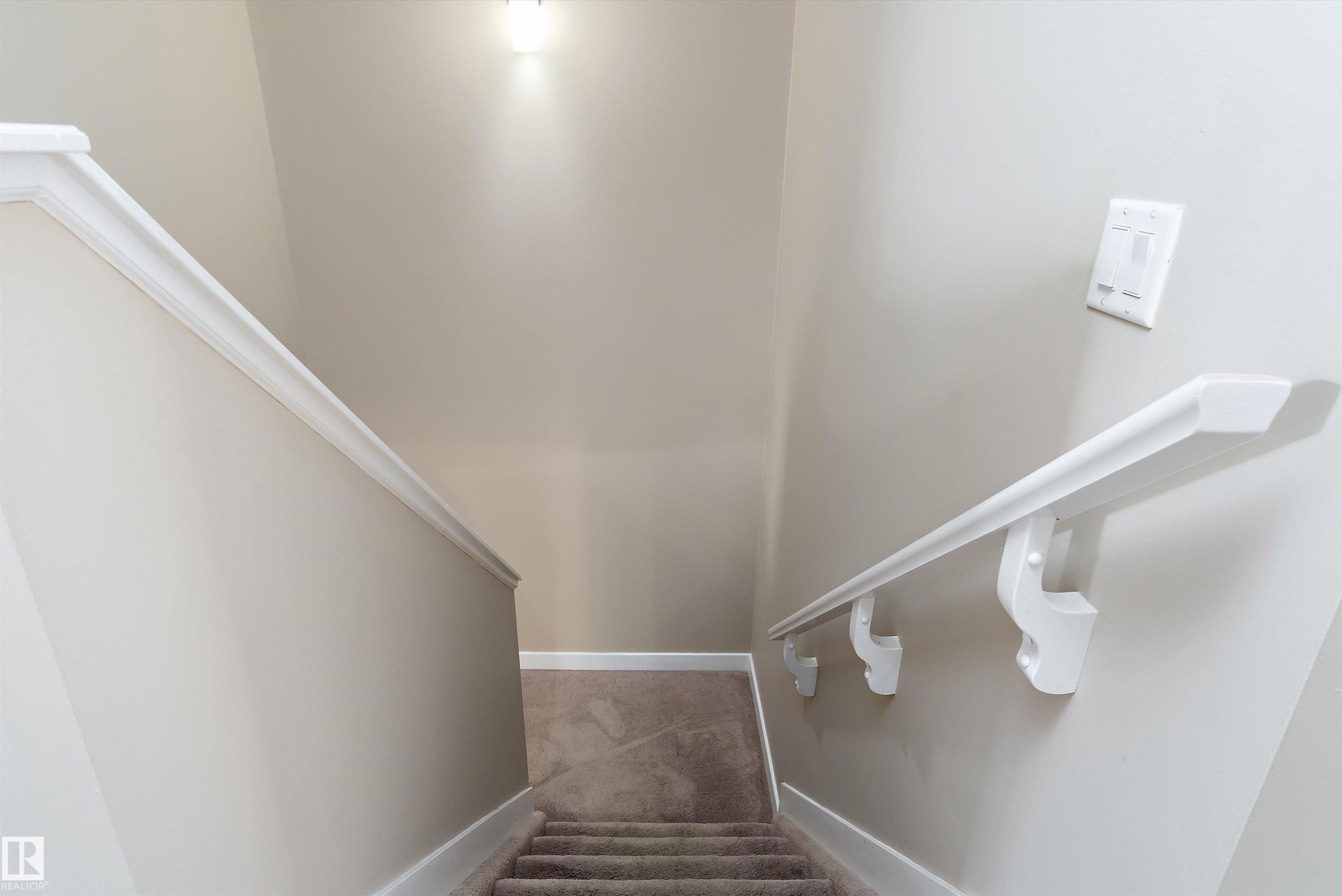 Carpeted staircase with light beige walls and white trim - 3314 9 Street Nw, Edmonton, AB - Indoor Photo Showing Other Room