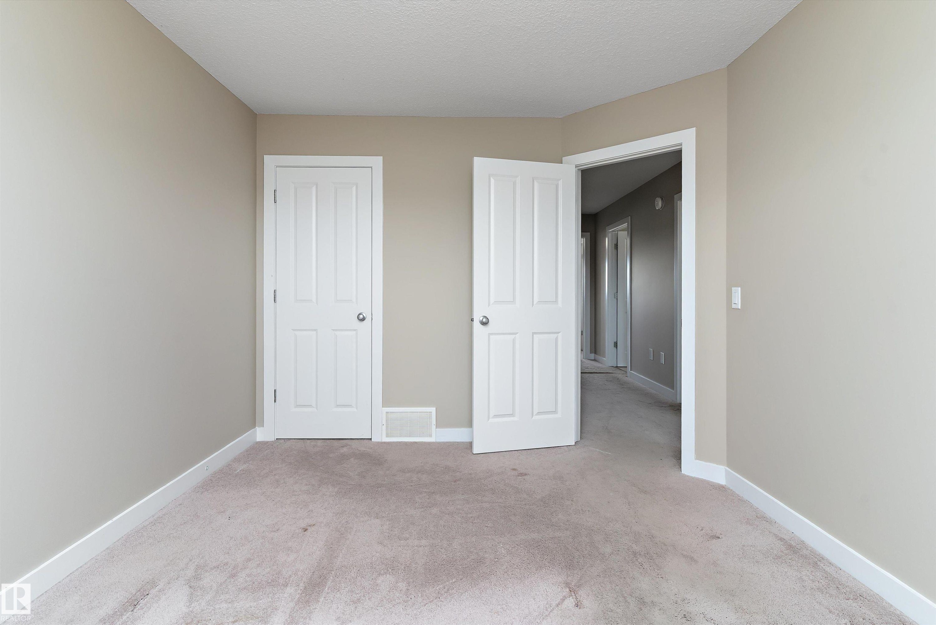 Neutral-toned walls complement the light carpet flooring - 3314 9 Street Nw, Edmonton, AB - Indoor Photo Showing Other Room