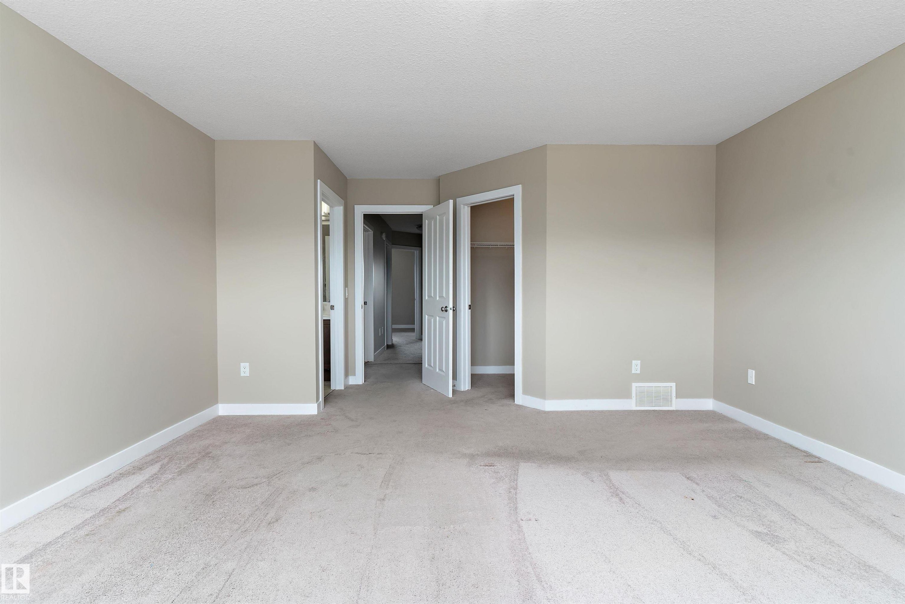Spacious carpeted room featuring neutral wall paint, white trim, and a built-in closet - 3314 9 Street Nw, Edmonton, AB - Indoor Photo Showing Other Room