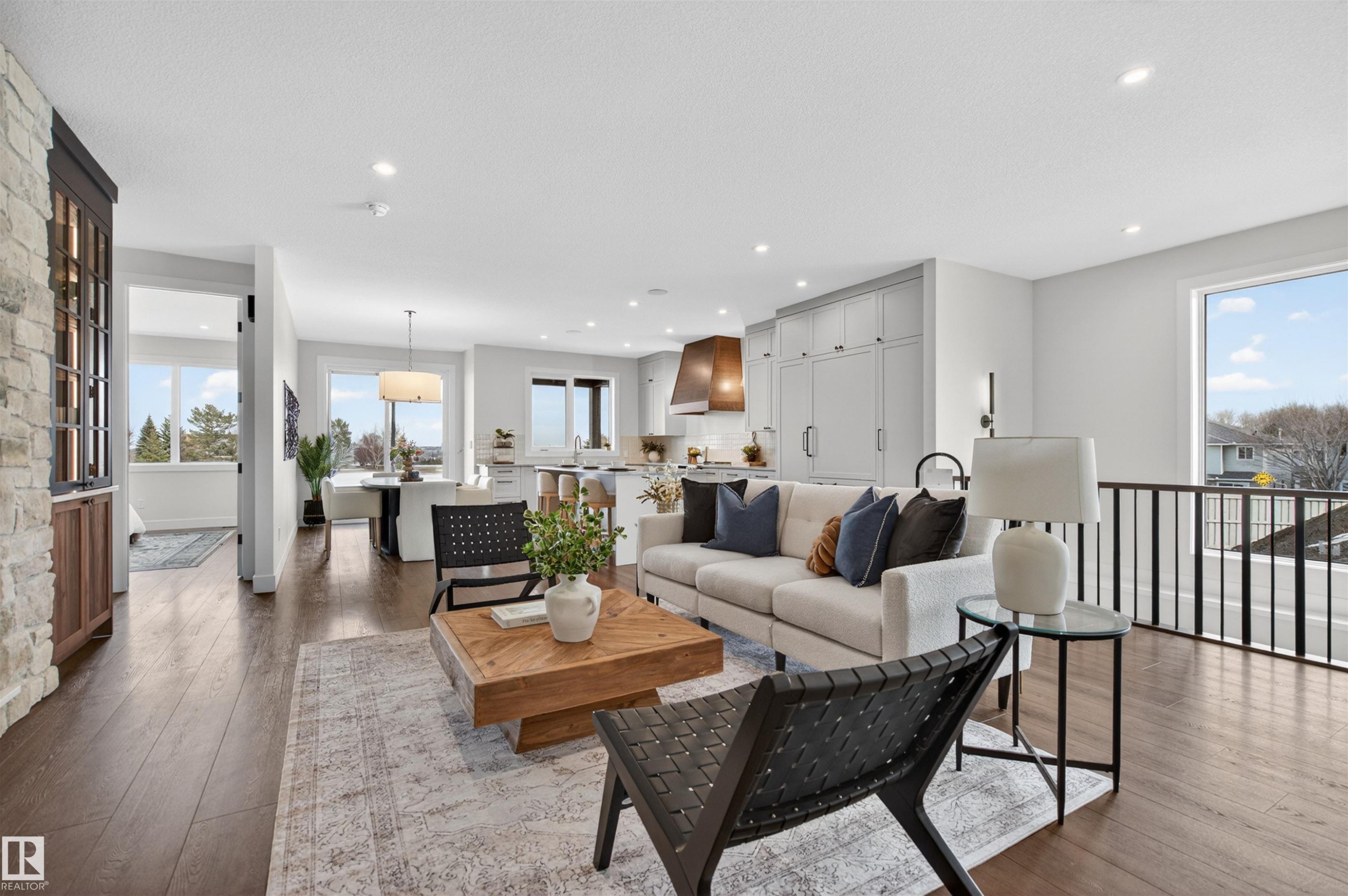 Open-concept living area featuring rich wood-finish flooring, a stone-clad architectural detail, and recessed lighting - 149 Eastgate Way, St. Albert, AB - Indoor Photo Showing Living Room