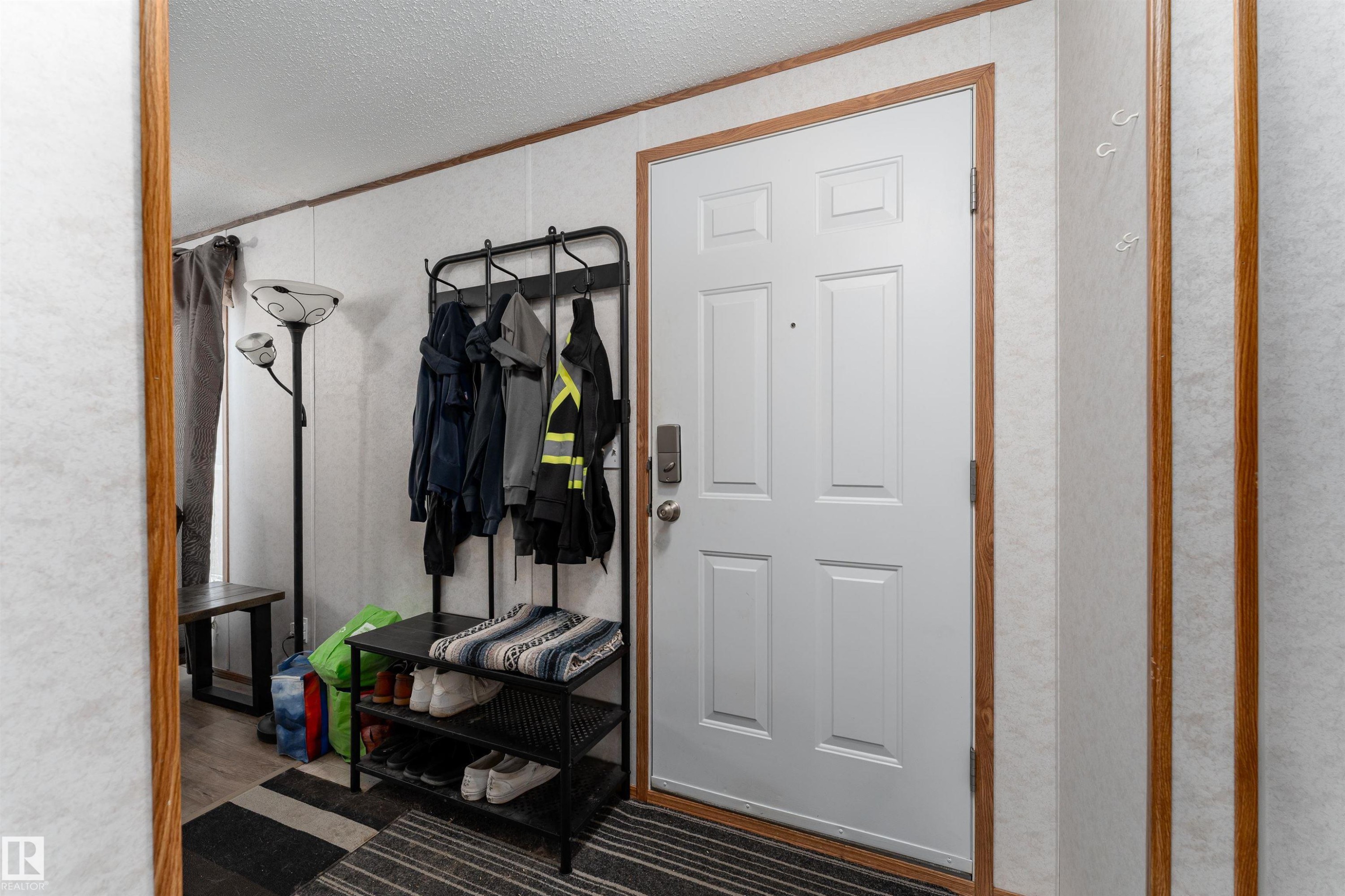 The property features a white paneled entry door with a door handle and deadbolt - 1663 Jubilee Crescent, Sherwood Park, AB - Indoor Photo Showing Other Room