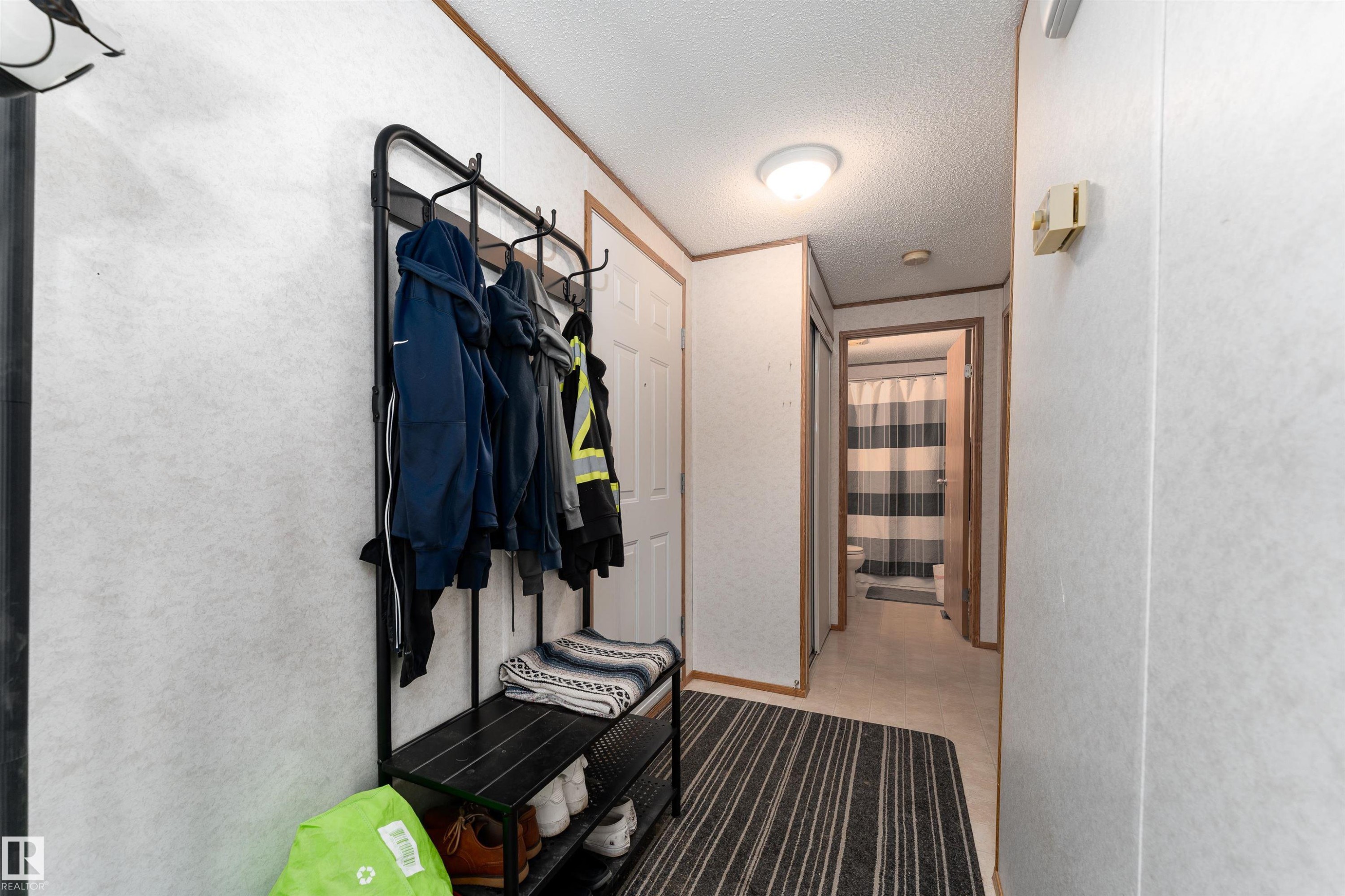The entry hallway features a light-colored ceiling and walls, with wood trim around the doorways - 1663 Jubilee Crescent, Sherwood Park, AB - Indoor