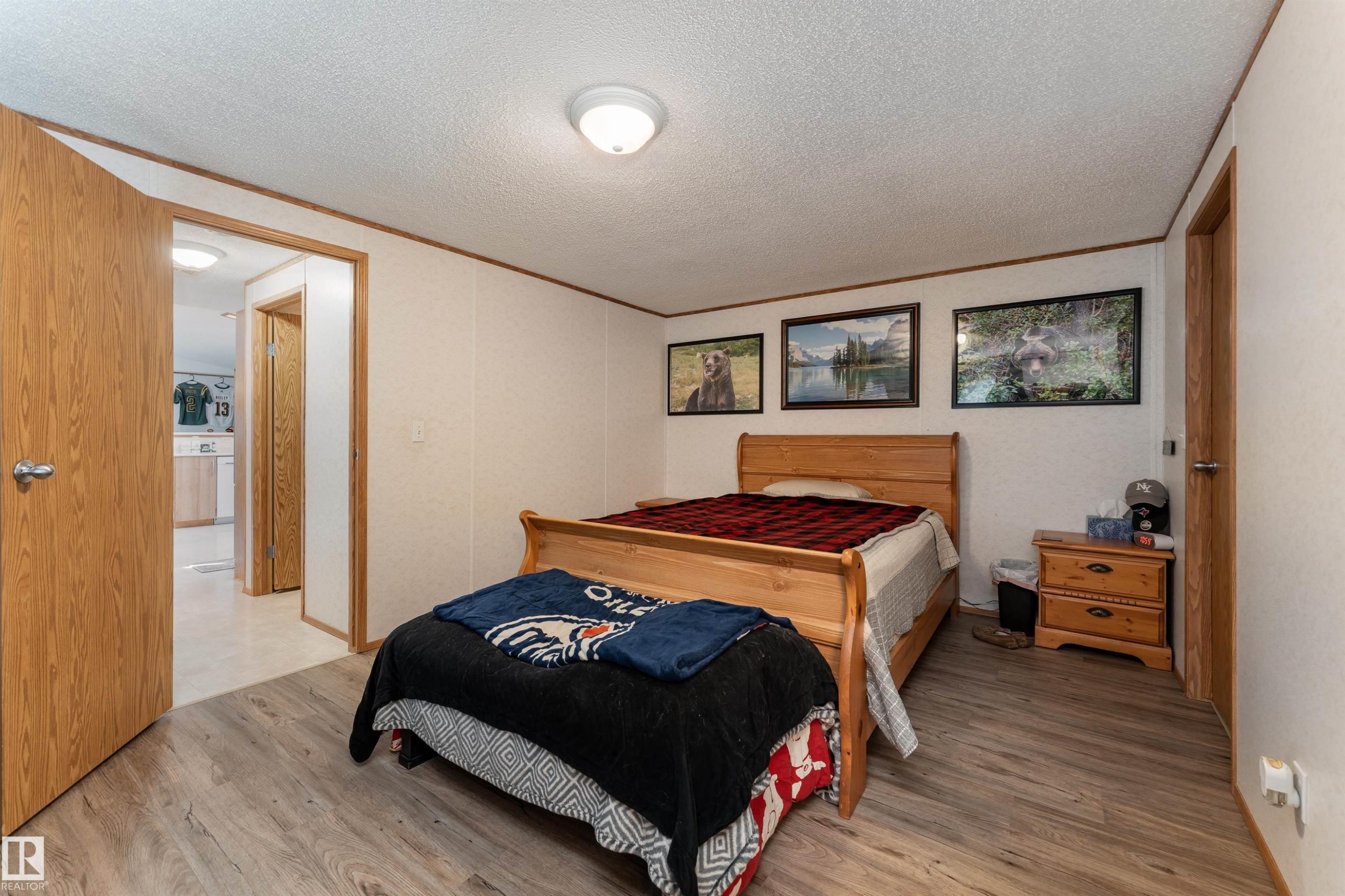 This room features light-colored walls, wood-look flooring, and a ceiling light fixture - 1663 Jubilee Crescent, Sherwood Park, AB - Indoor Photo Showing Bedroom