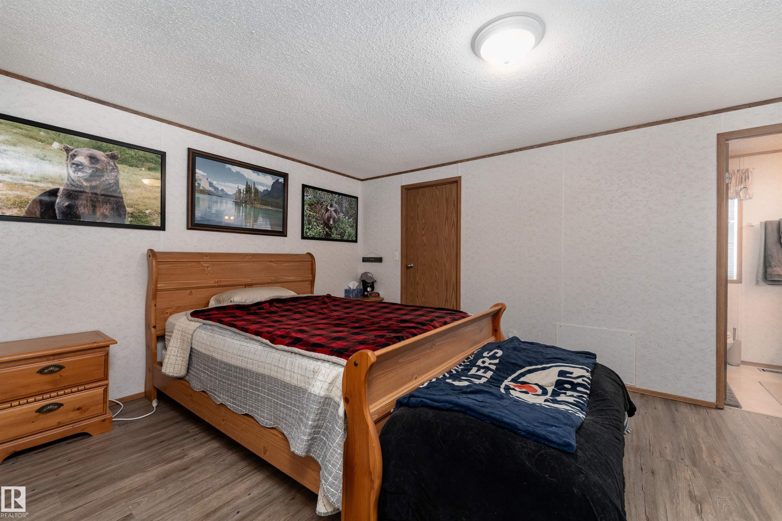 The property features an interior room with light-colored walls, a ceiling light fixture, and wood-toned trim - 1663 Jubilee Crescent, Sherwood Park, AB - Indoor Photo Showing Bedroom