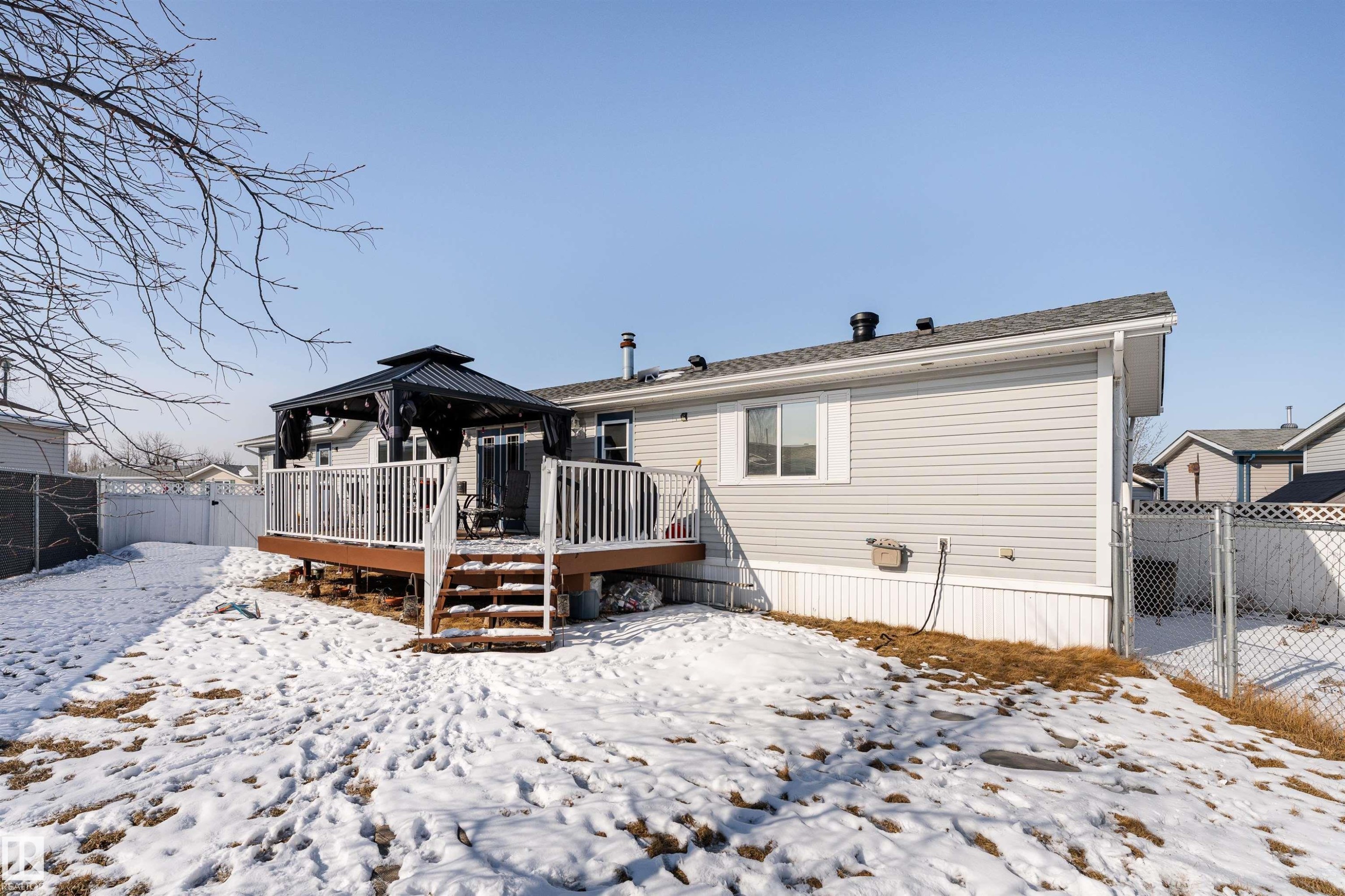 The property features a spacious rear deck with white railings, accessible via stairs - 1663 Jubilee Crescent, Sherwood Park, AB - Outdoor With Deck Patio Veranda
