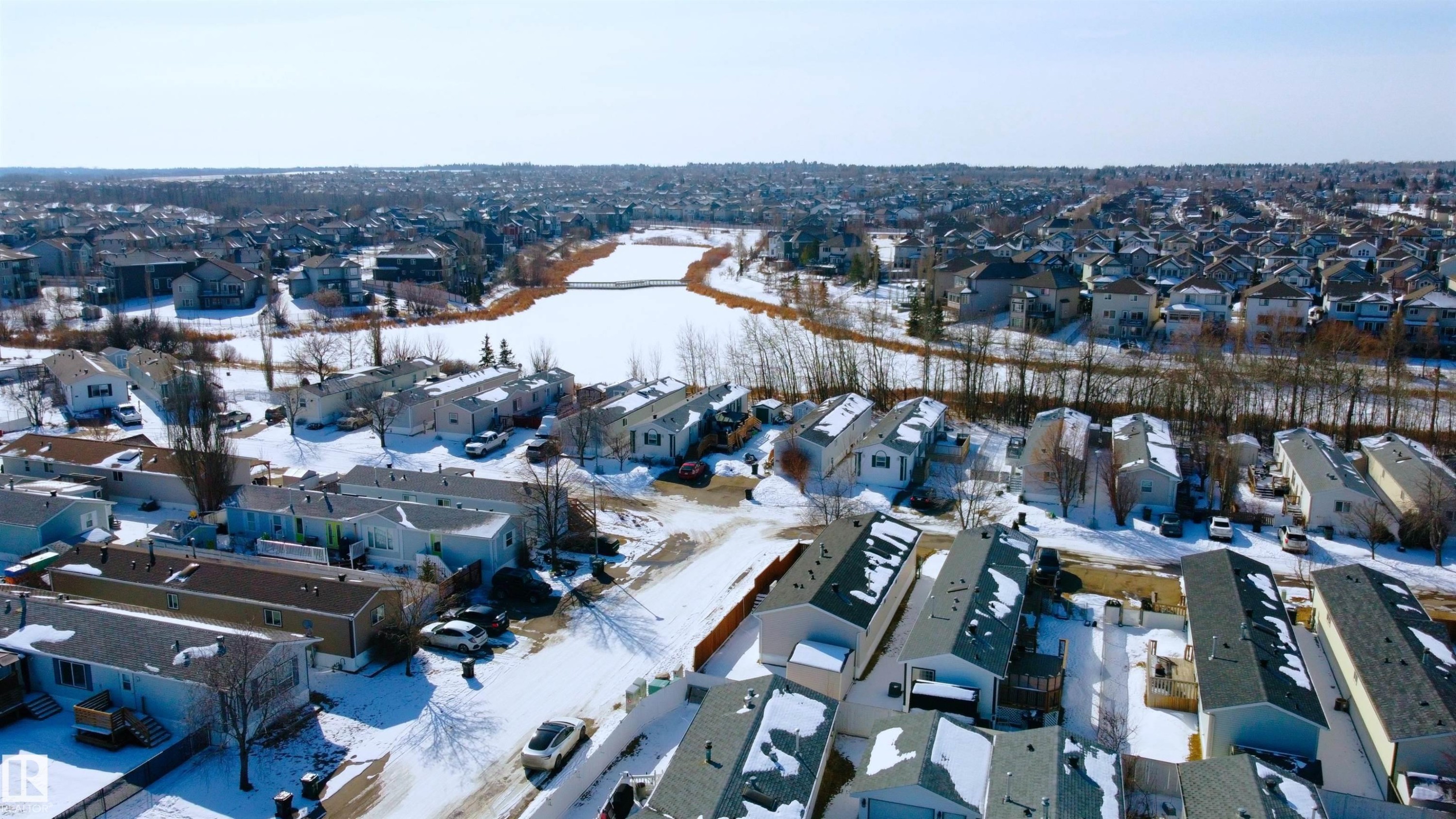 Aerial view showcasing a residential area with properties featuring shingled roofs and surrounding snow-covered terrain - 1663 Jubilee Crescent, Sherwood Park, AB - Outdoor With View