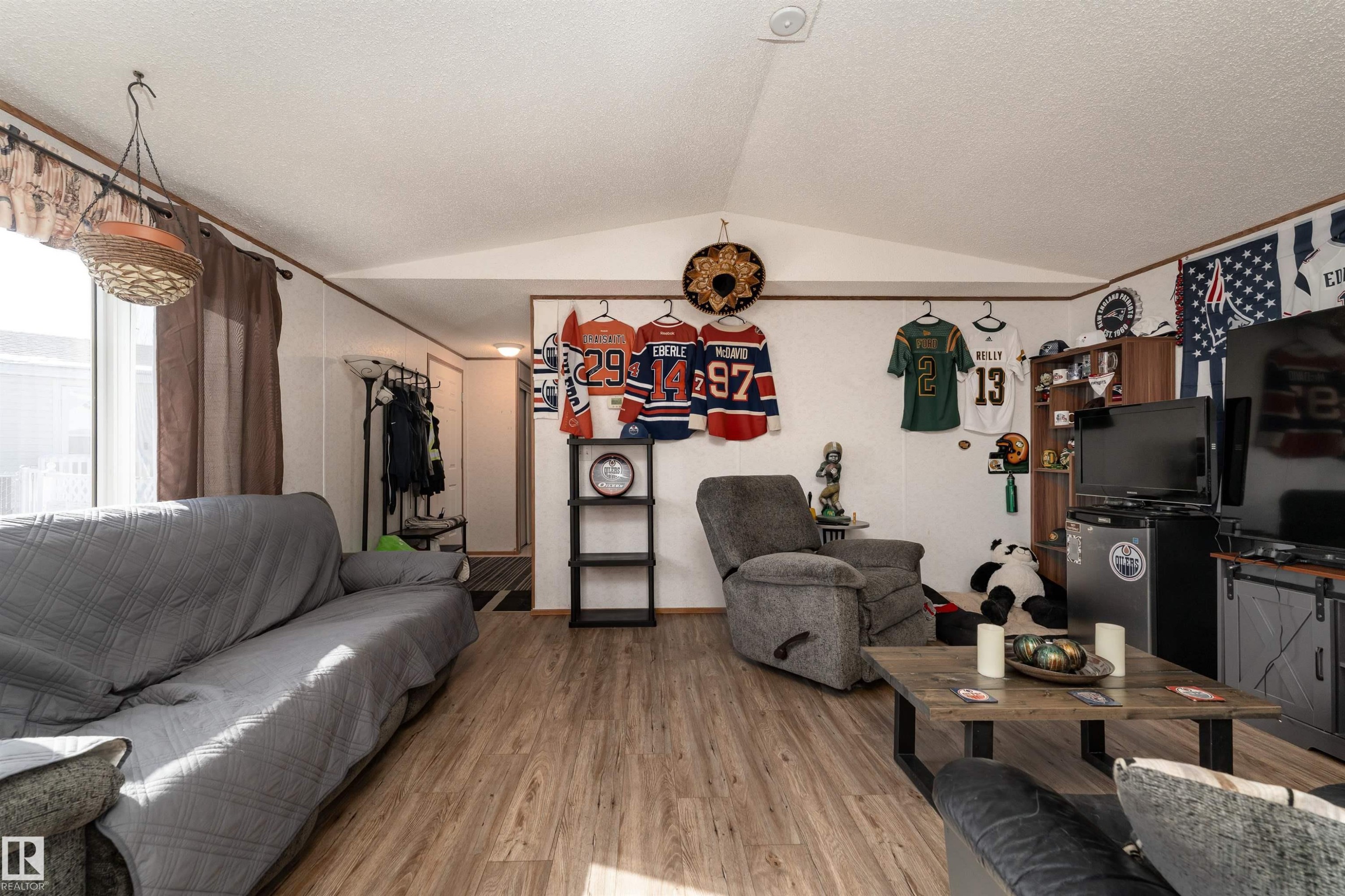 The room features light wood-look flooring and white walls, creating a bright and open atmosphere - 1663 Jubilee Crescent, Sherwood Park, AB - Indoor Photo Showing Living Room