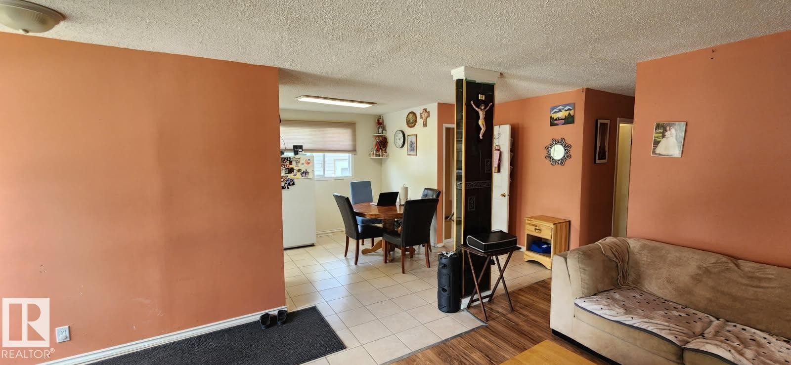 Kitchen and dining area featuring light-toned tile flooring, recessed lighting, and a window with a roller shade - 14411 31 Street, Edmonton, AB - Indoor