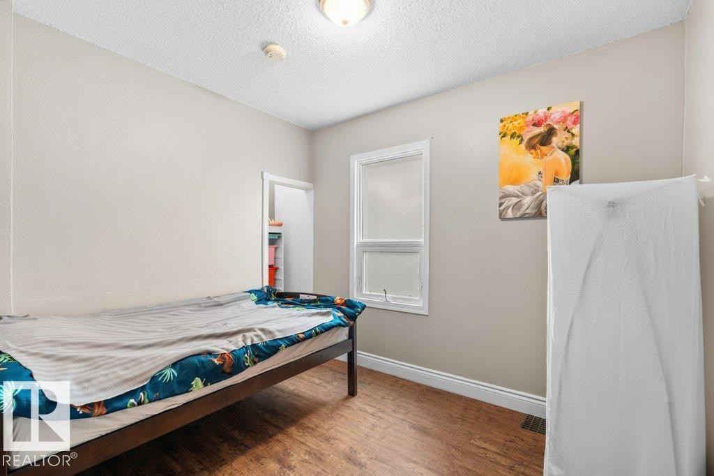 Room with wood-finish flooring, light grey walls, and a white trim window - 12207 110 Avenue, Edmonton, AB - Indoor Photo Showing Other Room