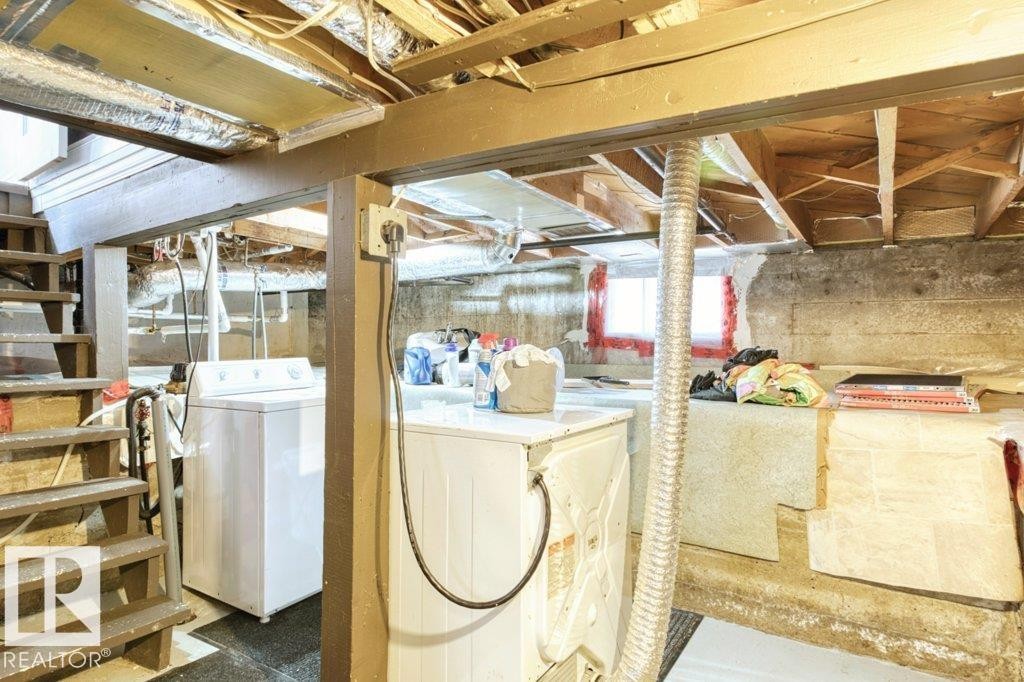Basement area featuring exposed wood joists and support beams, a utility sink, and a washer and dryer - 12207 110 Avenue, Edmonton, AB - Indoor Photo Showing Laundry Room