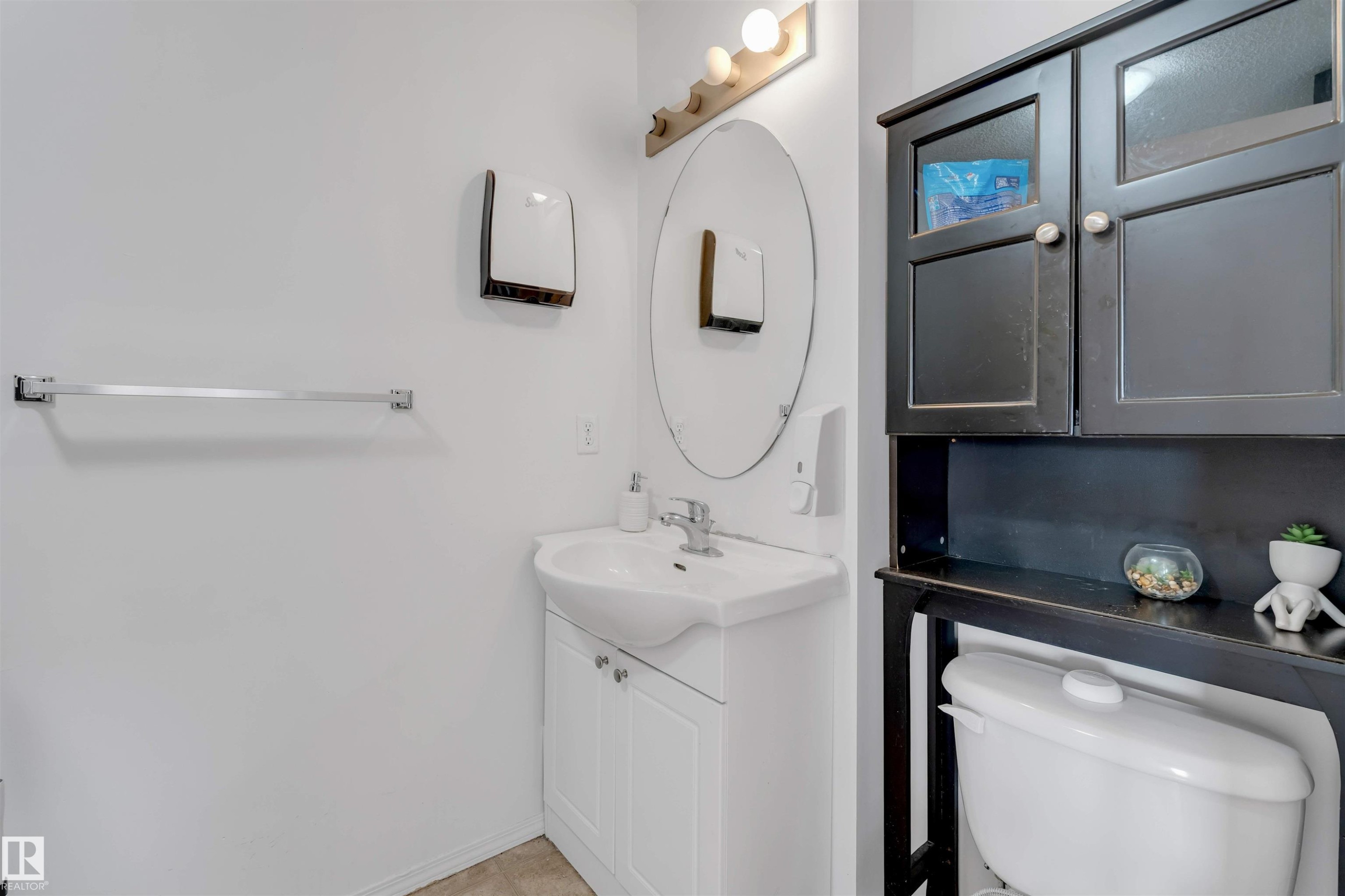 Bathroom vanity with white cabinetry, a ceramic sink, and chrome faucet hardware - 48 2503 24 Street, Edmonton, AB - Indoor Photo Showing Bathroom