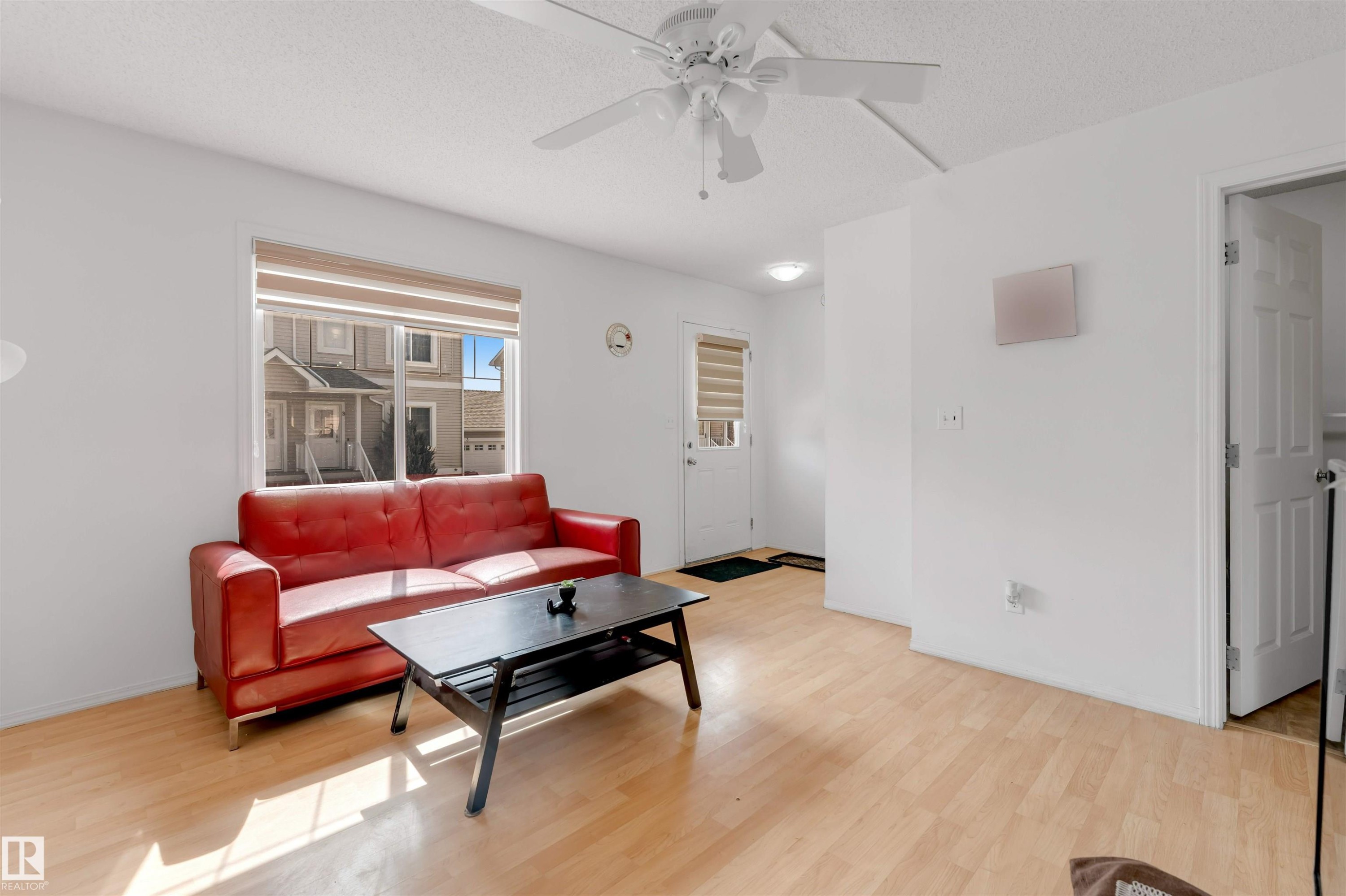 Living area featuring light wood-finish flooring, white walls, and a ceiling fan - 48 2503 24 Street, Edmonton, AB - Indoor Photo Showing Living Room