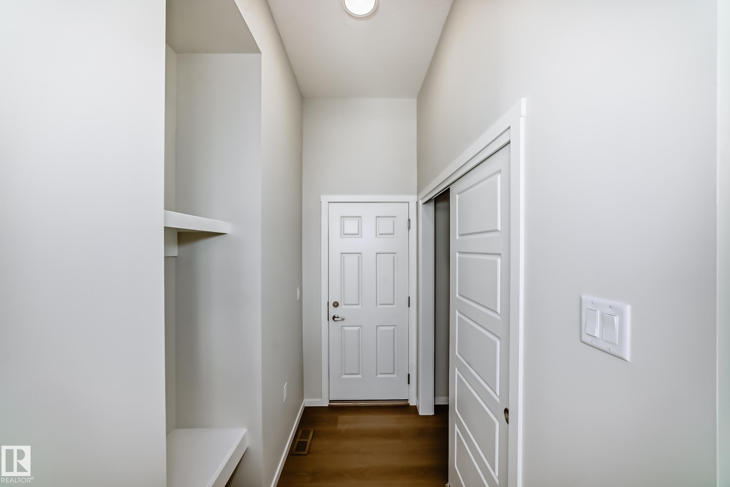 Entryway with hardwood flooring, a white paneled door, and built-in shelving - 1516 206 Street Nw, Edmonton, AB - Indoor Photo Showing Other Room