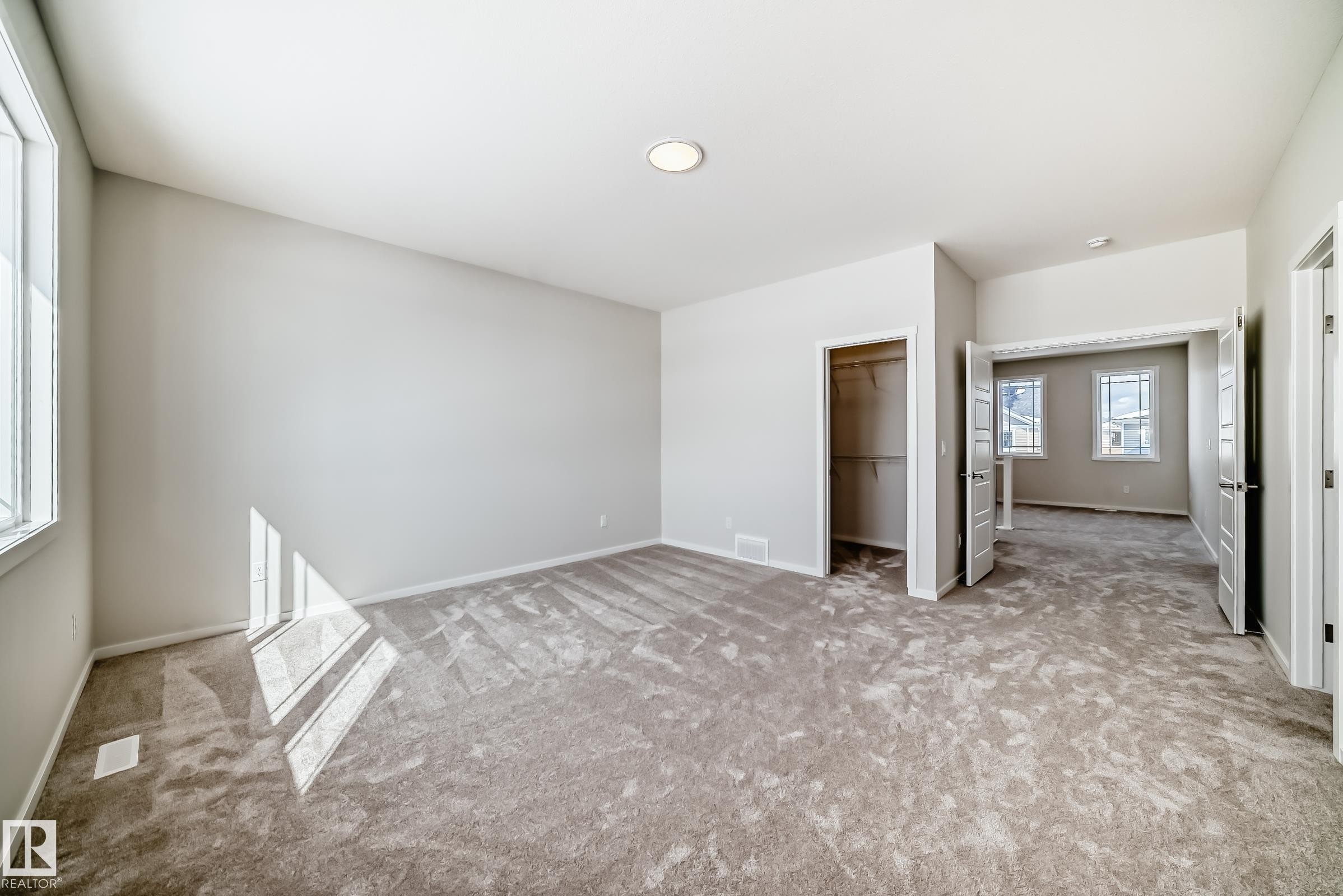 Spacious room featuring light gray walls, plush carpet flooring, a recessed ceiling light, and an open closet - 1516 206 Street Nw, Edmonton, AB - Indoor Photo Showing Other Room