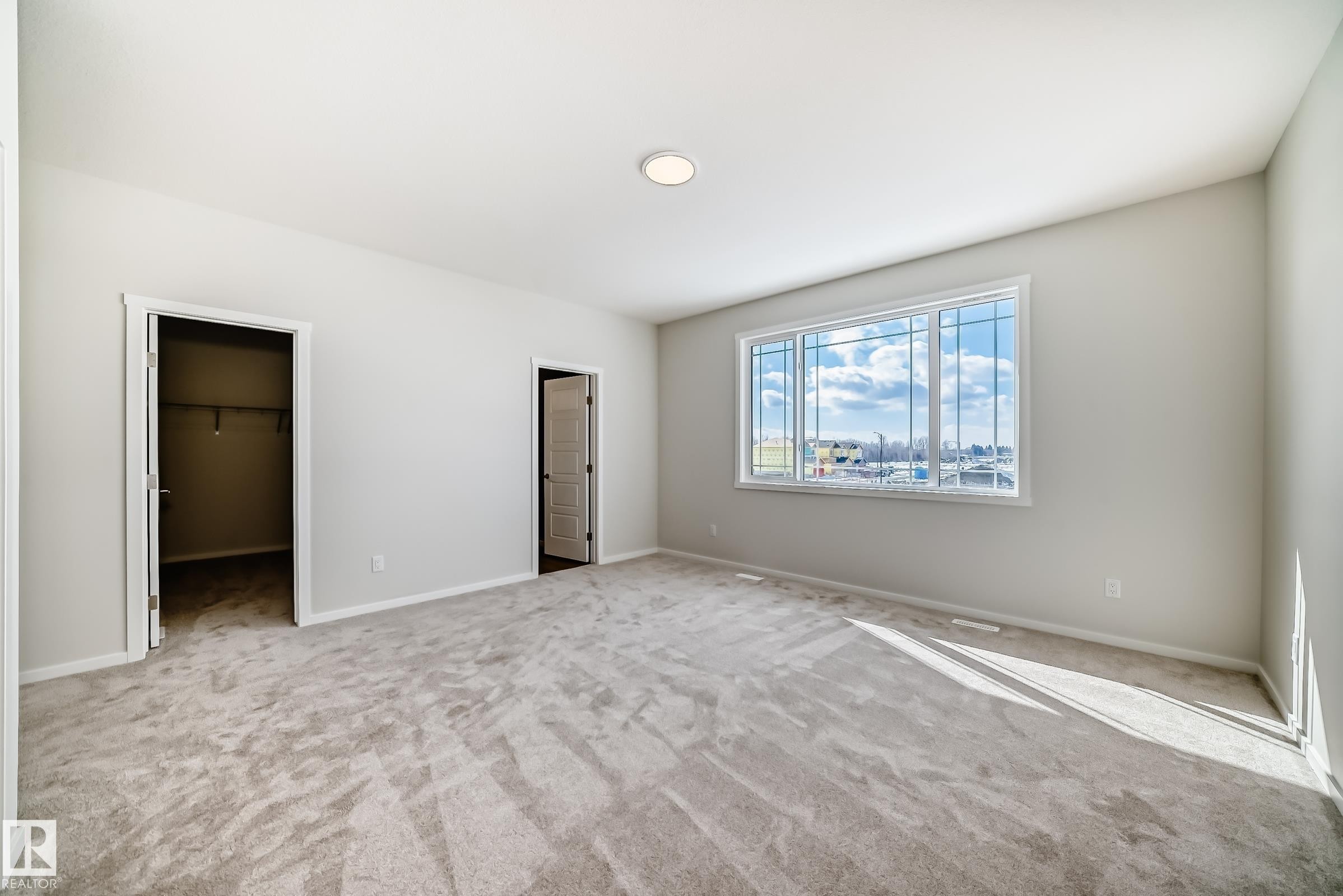 The property features light-colored walls, carpeted flooring, and a window providing natural light - 1516 206 Street Nw, Edmonton, AB - Indoor Photo Showing Other Room