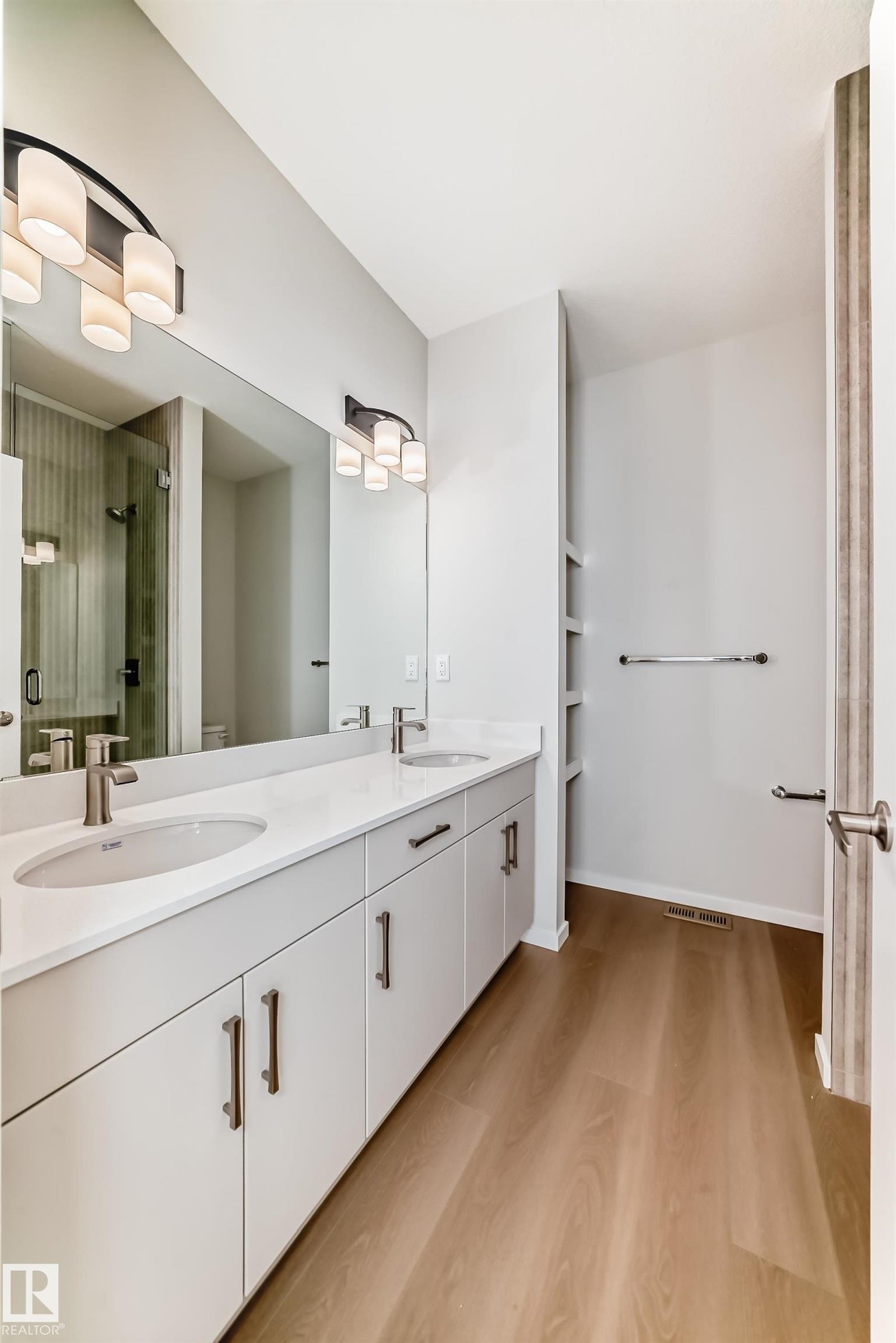 Bathroom featuring a double vanity with light-colored cabinetry, undermount sinks, and a long mirror - 1516 206 Street Nw, Edmonton, AB - Indoor Photo Showing Bathroom