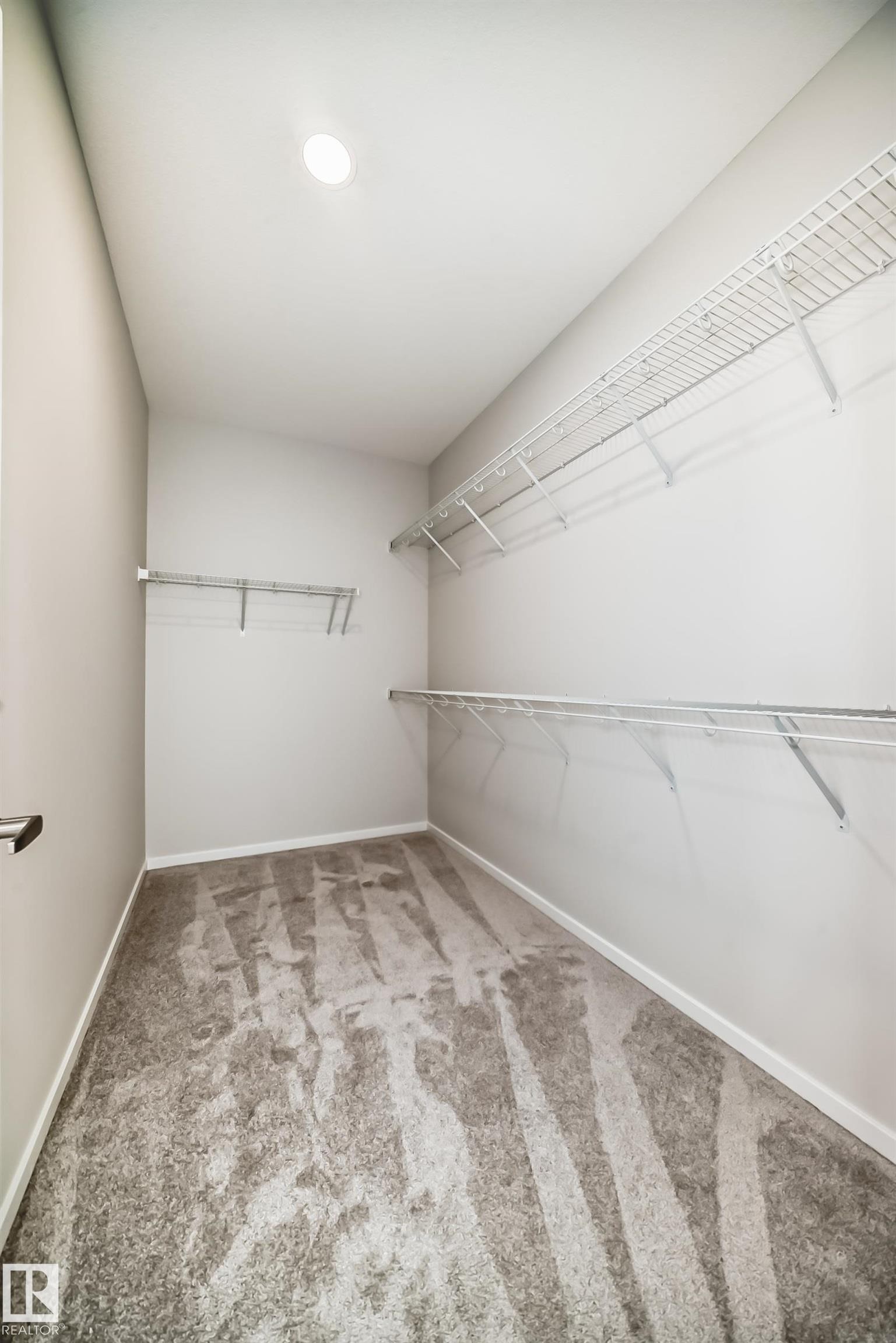 Walk-in closet featuring light gray carpeting, white walls, and wire shelving for storage - 1516 206 Street Nw, Edmonton, AB - Indoor With Storage