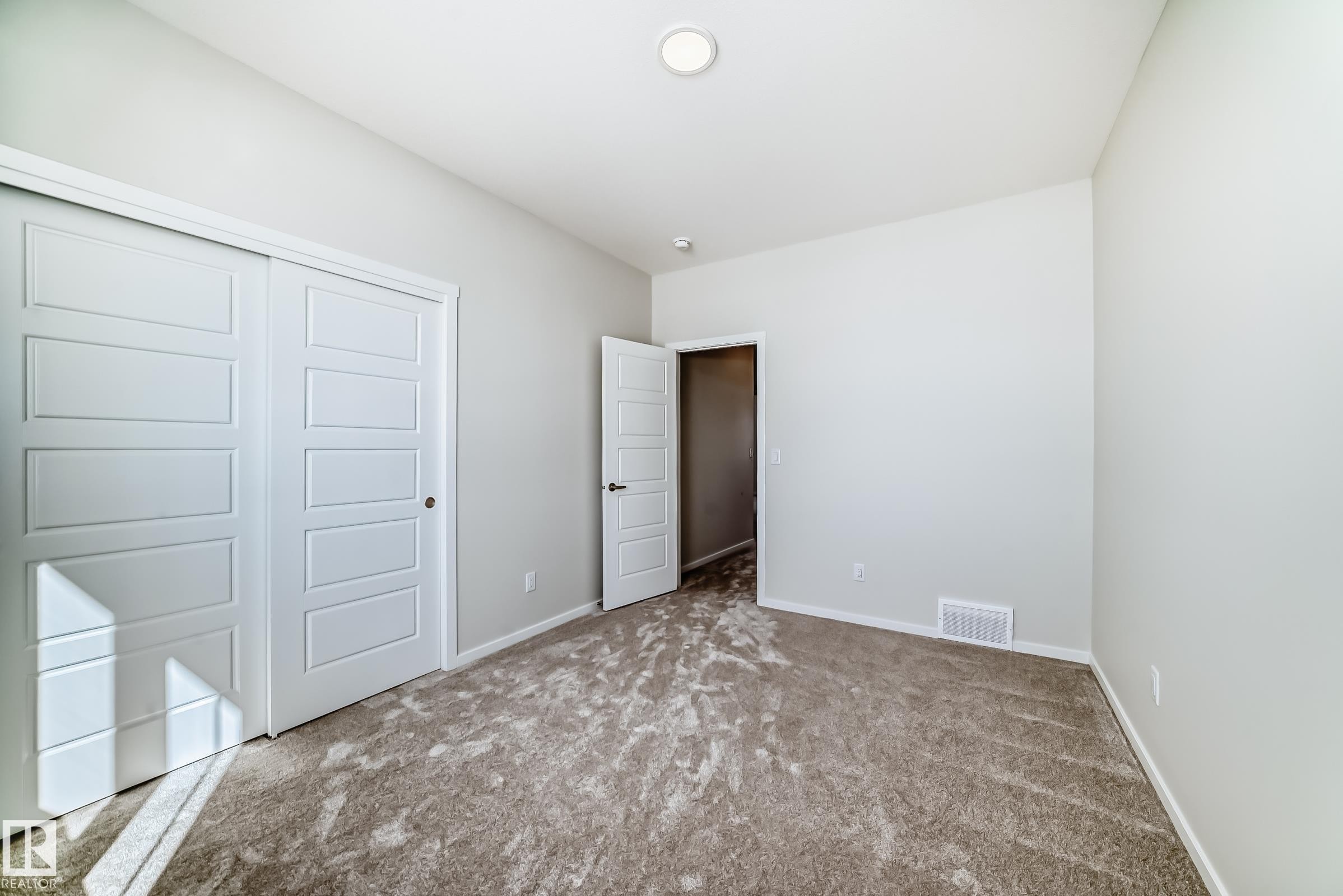 This room features light gray walls, a textured gray carpet, and white trim - 1516 206 Street Nw, Edmonton, AB - Indoor Photo Showing Other Room