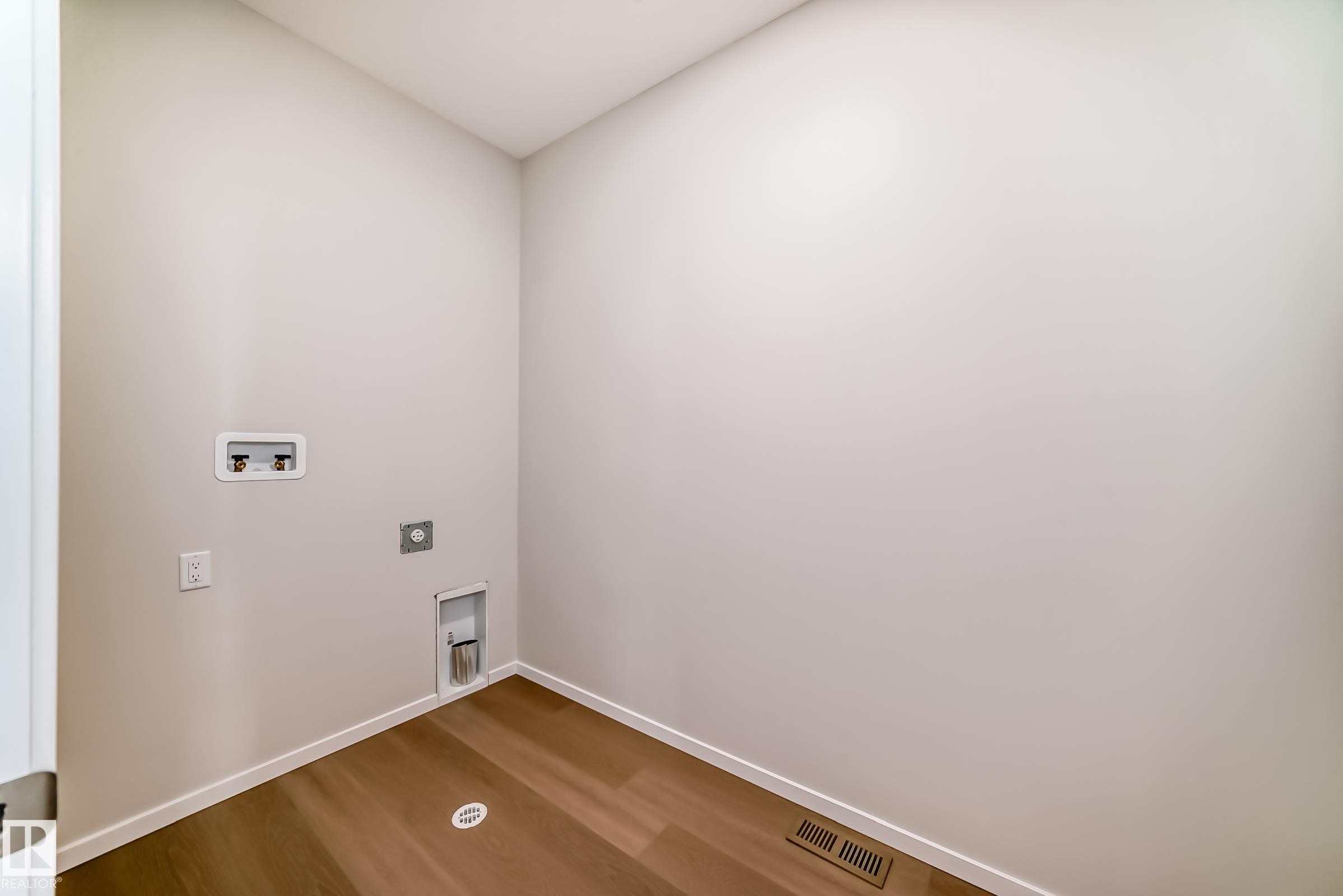 Laundry area featuring light-colored walls and wood-look flooring - 1516 206 Street Nw, Edmonton, AB - Indoor Photo Showing Other Room