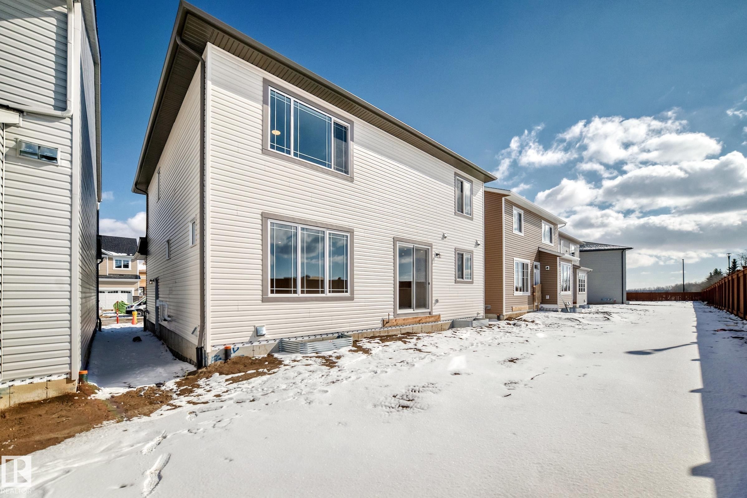 The property features a spacious backyard with a fence and a sliding glass door for outdoor access - 1516 206 Street Nw, Edmonton, AB - Outdoor
