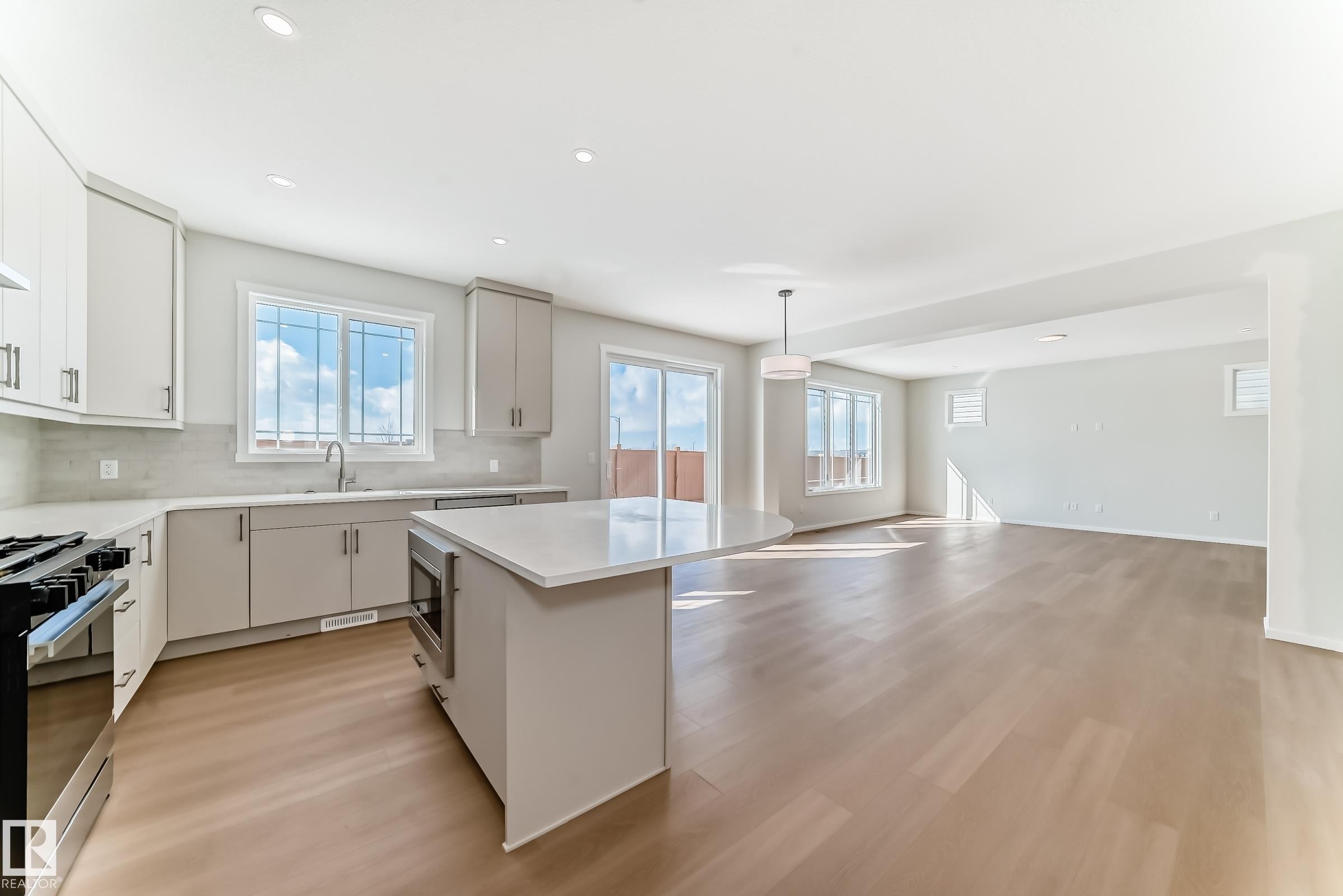 The property features an open concept kitchen and living area, complete with a kitchen island, recessed lighting, and hardwood flooring - 1516 206 Street Nw, Edmonton, AB - Indoor Photo Showing Kitchen With Upgraded Kitchen