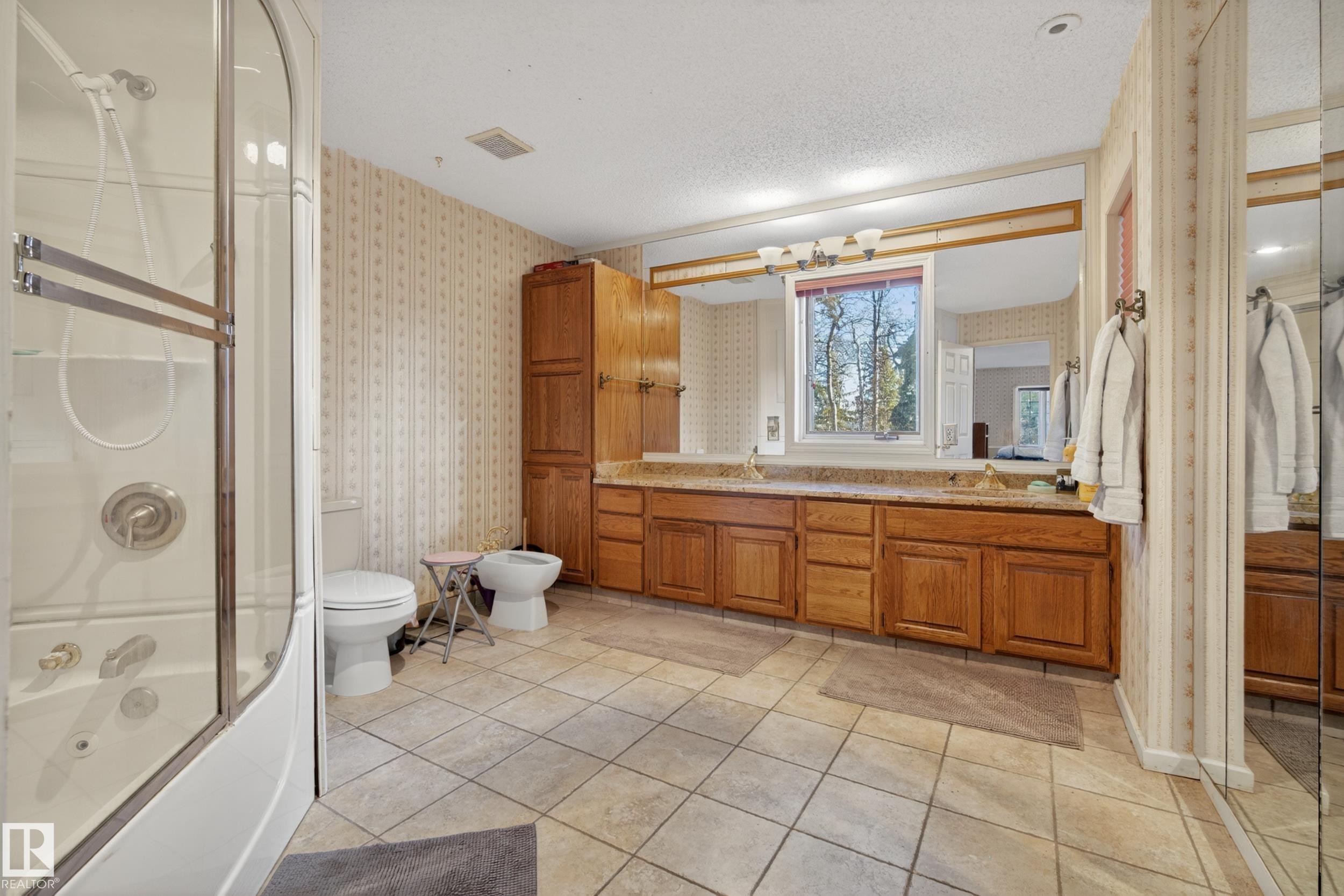 Bathroom featuring a combination shower and jetted tub, dual vanity with a large mirror, and tiled flooring - 33 Glen Meadow Crescent, St. Albert, AB - Indoor Photo Showing Bathroom