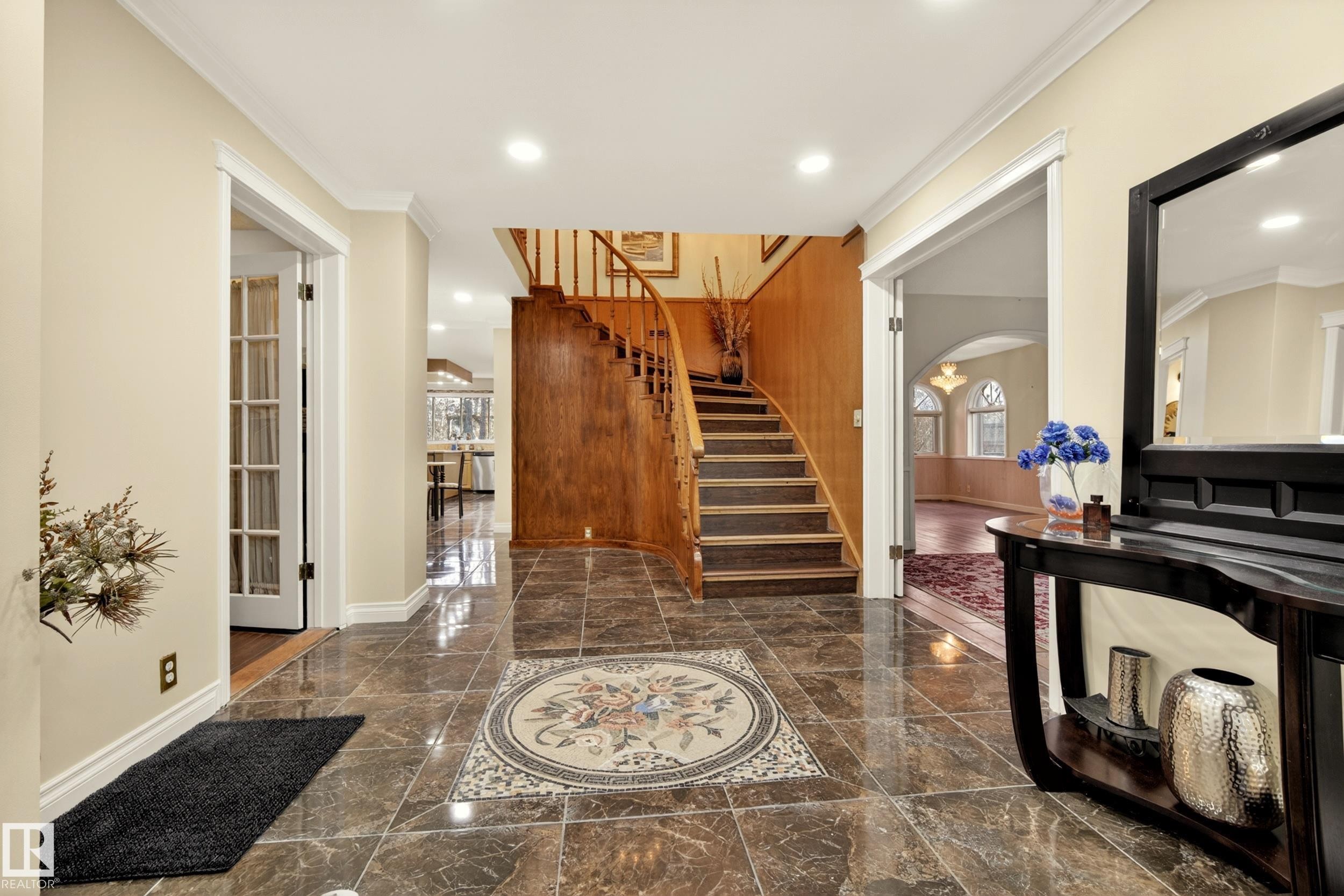 Entryway featuring polished stone tile flooring with an intricate mosaic inlay, a curved wood staircase, recessed lighting, and crown molding - 33 Glen Meadow Crescent, St. Albert, AB - Indoor Photo Showing Other Room