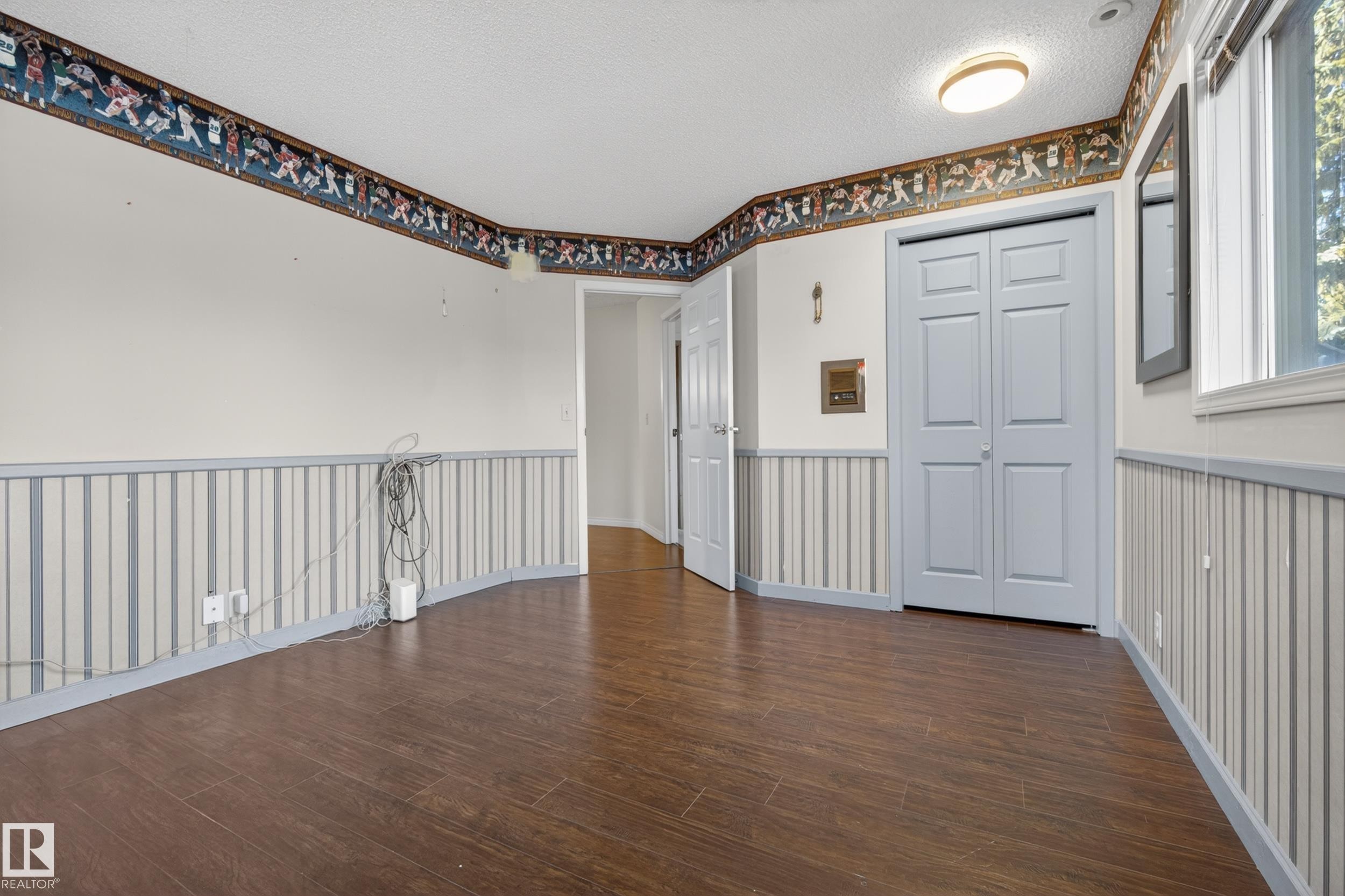 Spacious room featuring wood-finish flooring, white walls, and a textured ceiling - 33 Glen Meadow Crescent, St. Albert, AB - Indoor Photo Showing Other Room