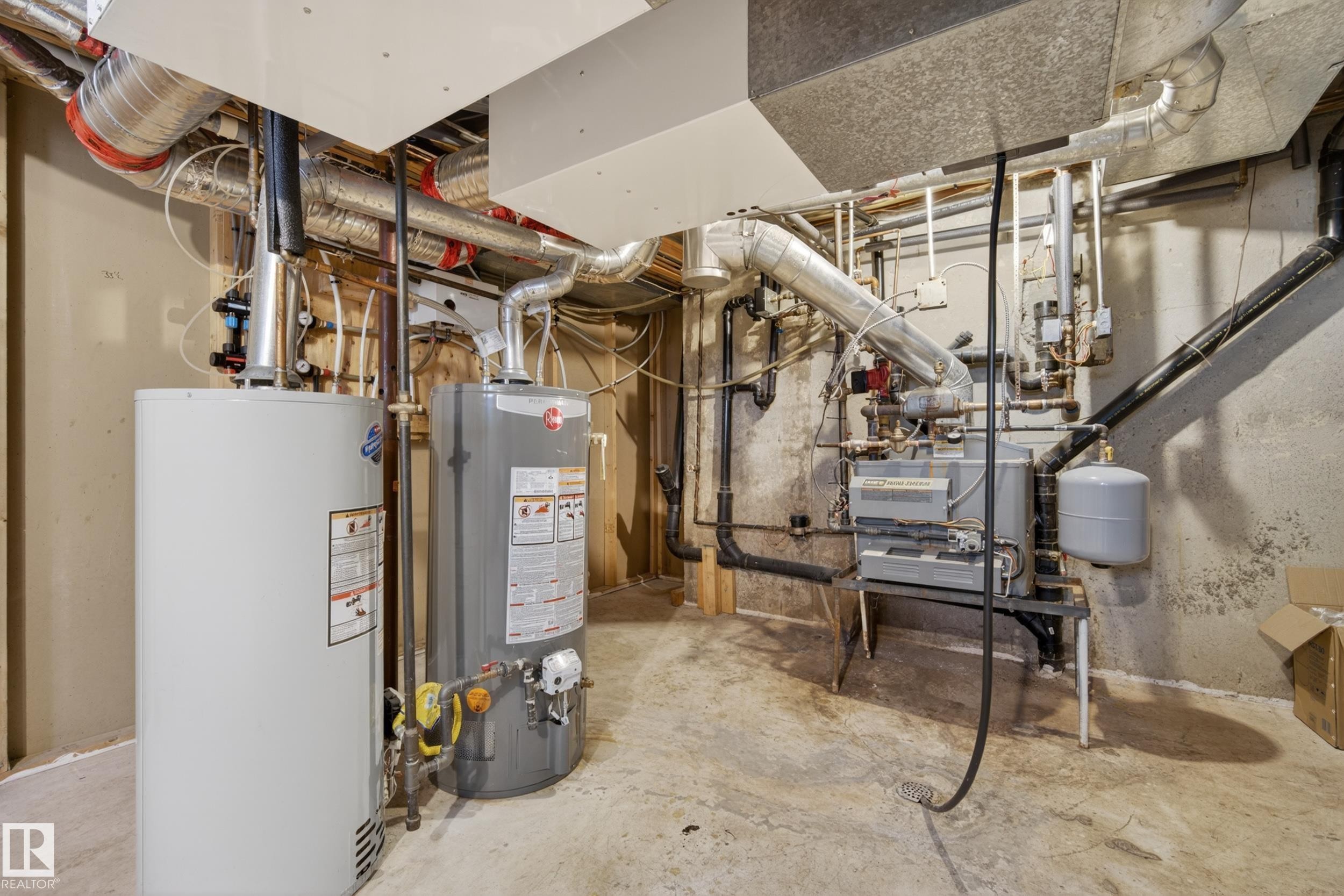Utility area featuring two water heaters, extensive ductwork, and a furnace unit - 33 Glen Meadow Crescent, St. Albert, AB - Indoor Photo Showing Basement