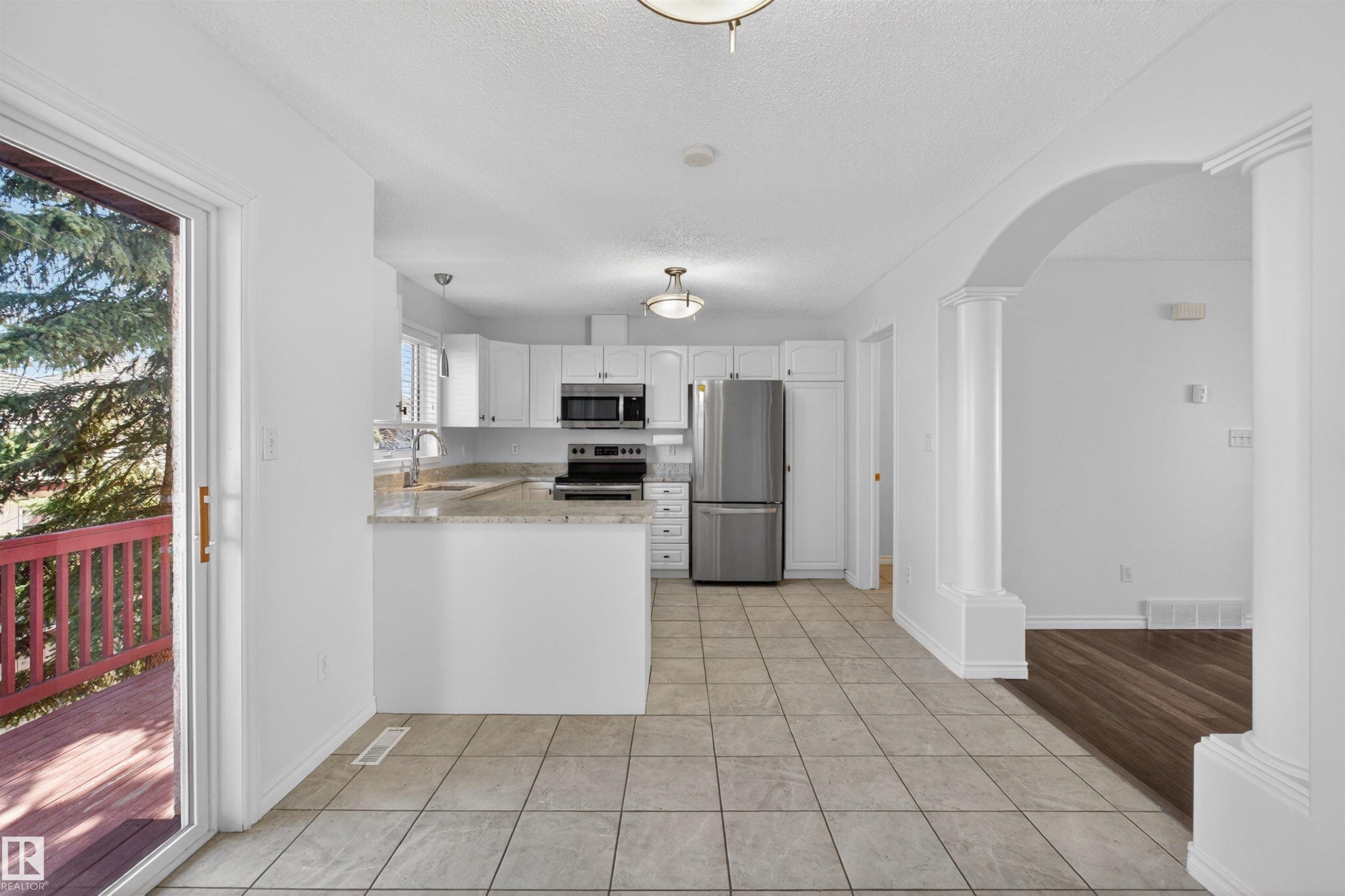 Modern kitchen featuring white cabinetry, stainless steel appliances, and light-toned countertops - 6 1237 Carter Crest Road, Edmonton, AB