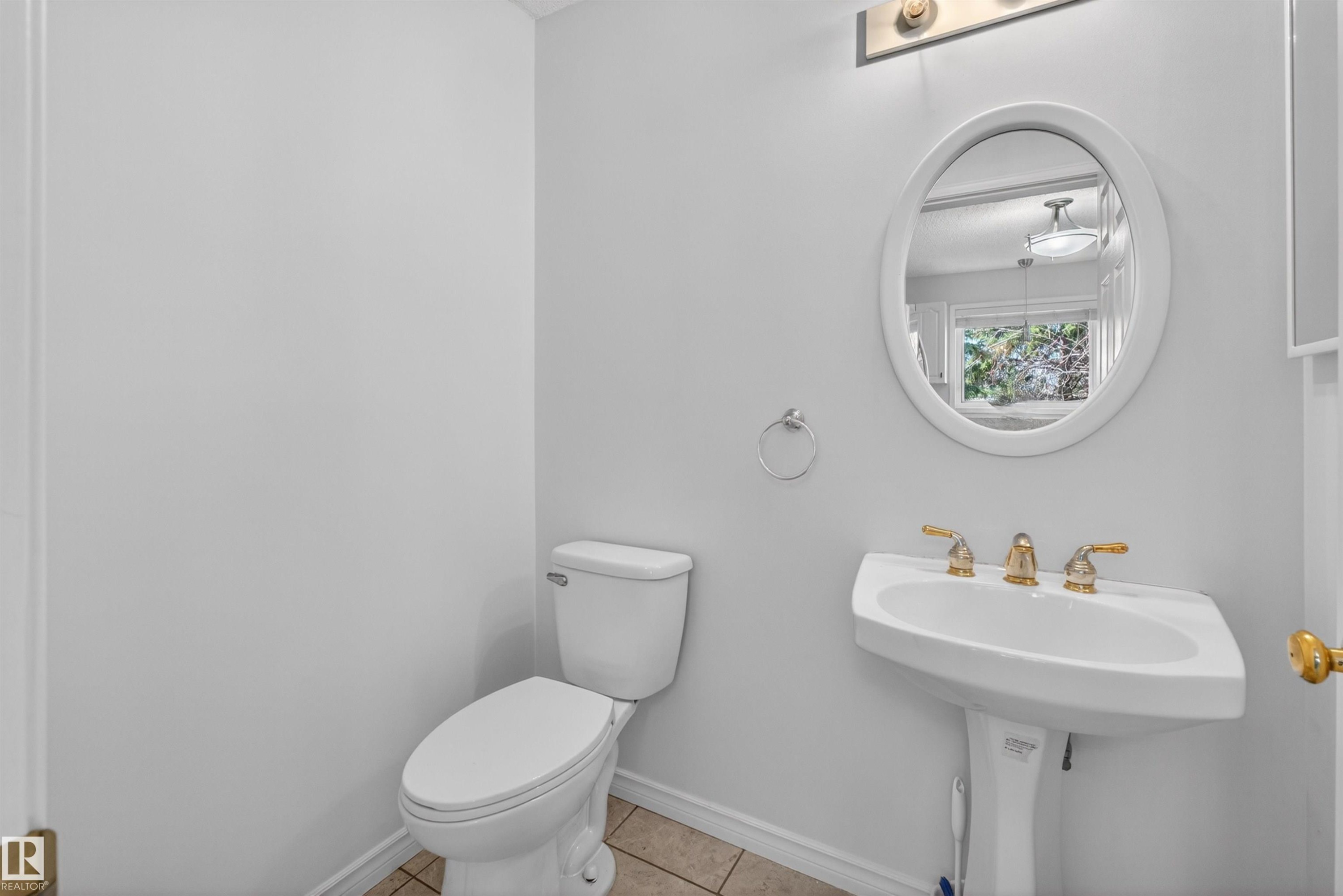 Pedestal sink with brass-finish faucet and oval mirror - 6 1237 Carter Crest Road, Edmonton, AB