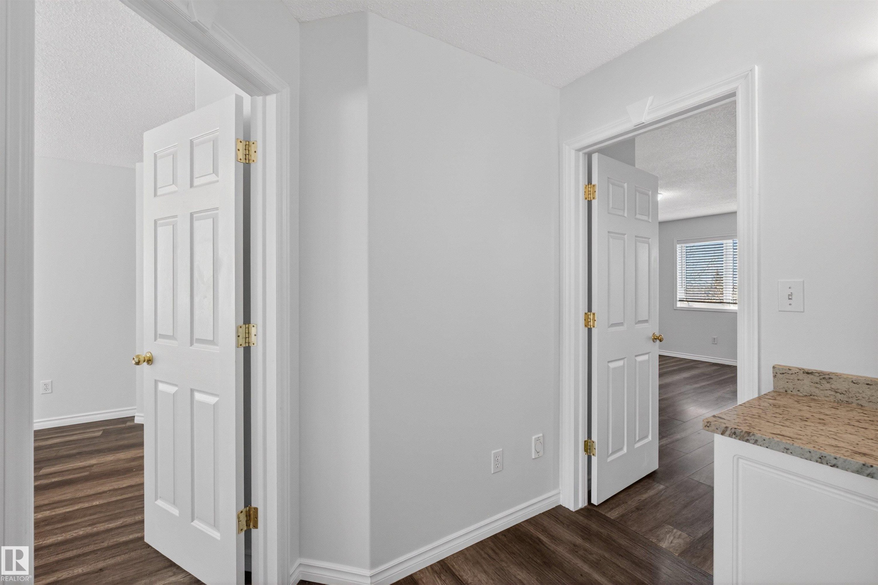 Hallway with light gray walls and wood-finish flooring - 6 1237 Carter Crest Road, Edmonton, AB