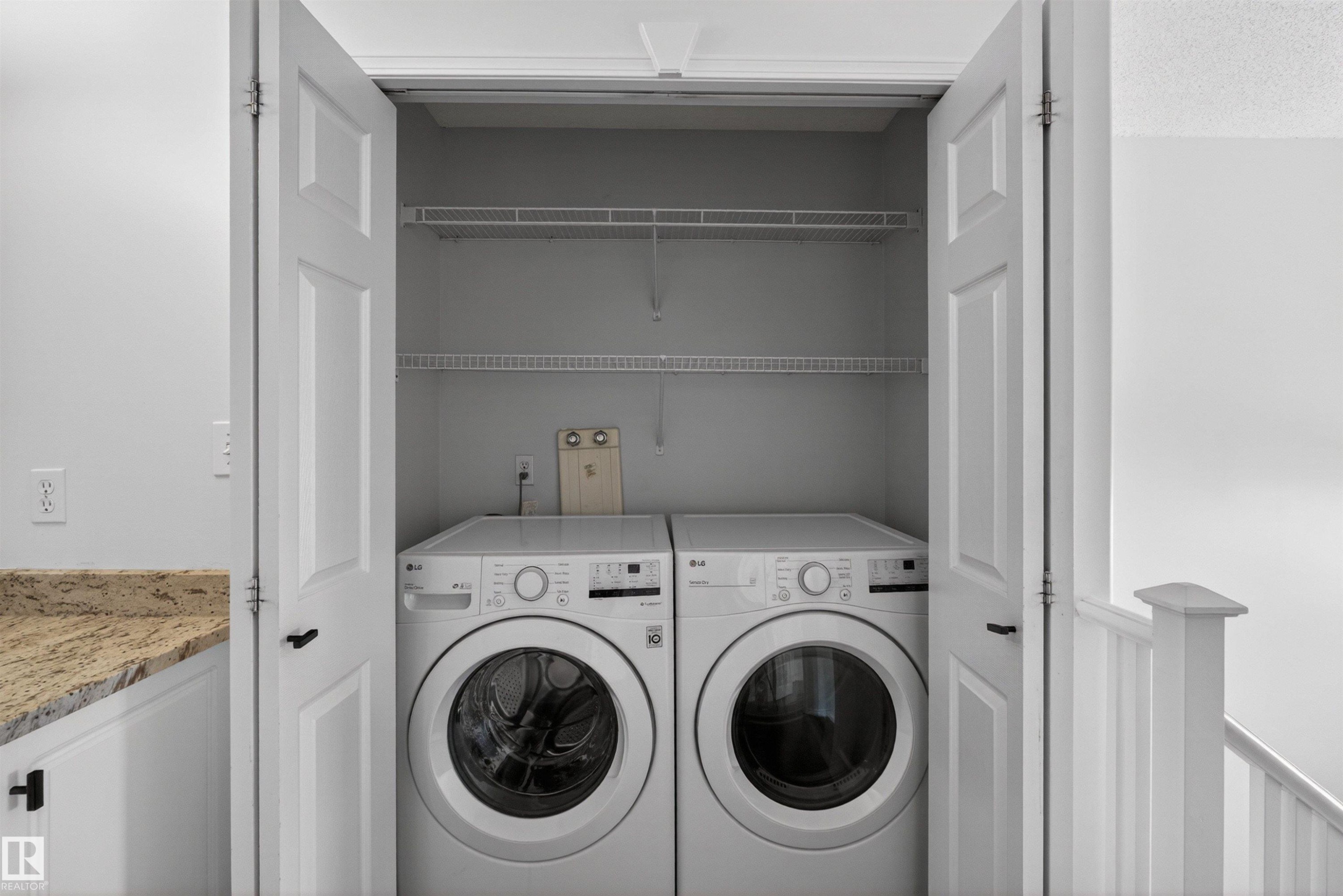 Integrated laundry closet featuring white bi-fold doors and overhead wire shelving - 6 1237 Carter Crest Road, Edmonton, AB