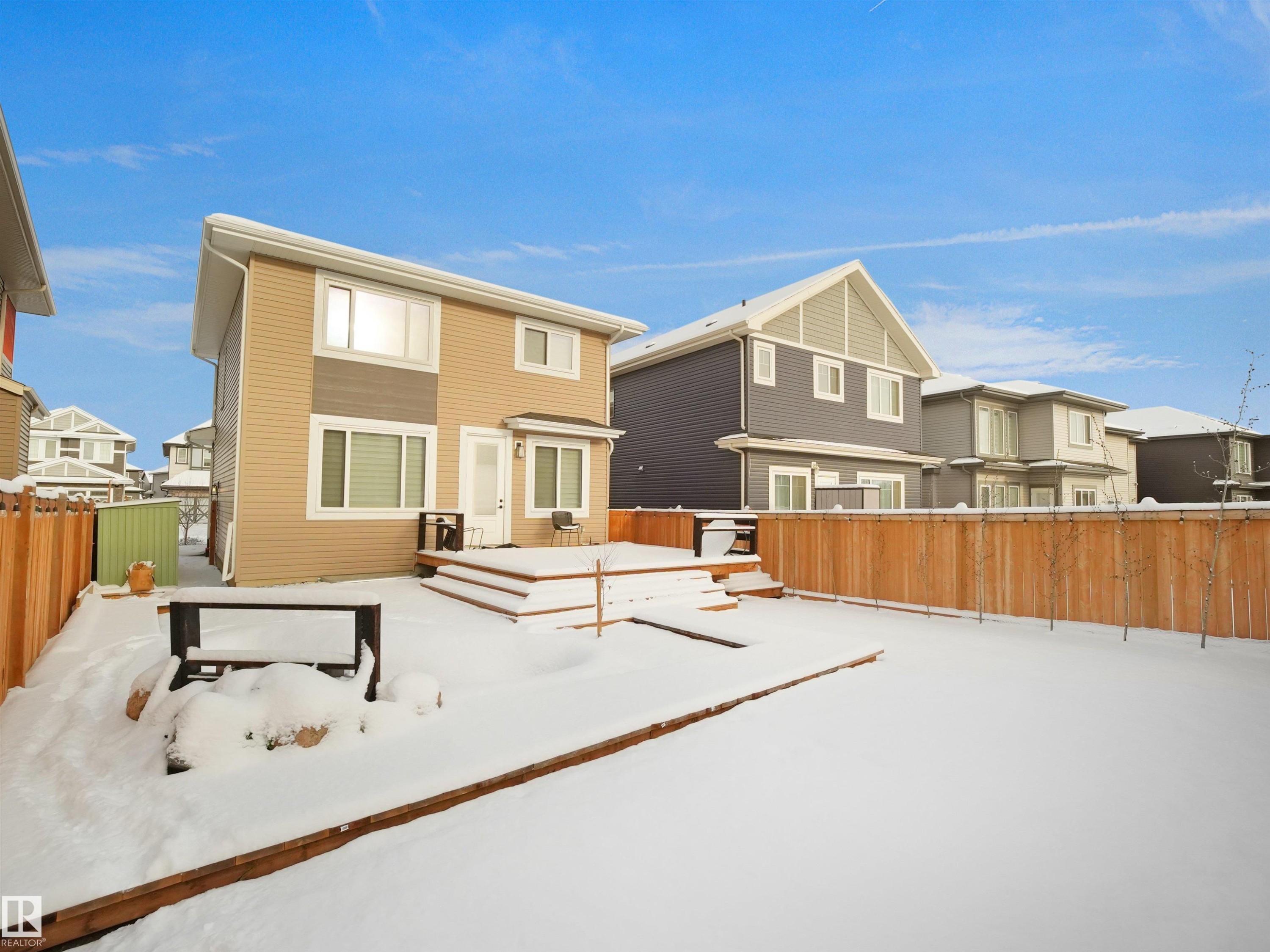 Expansive backyard featuring a tiered wooden deck, wood privacy fencing, and a built-in fire pit area - 20827 130 Avenue Nw, Edmonton, AB - Outdoor With Deck Patio Veranda With Exterior