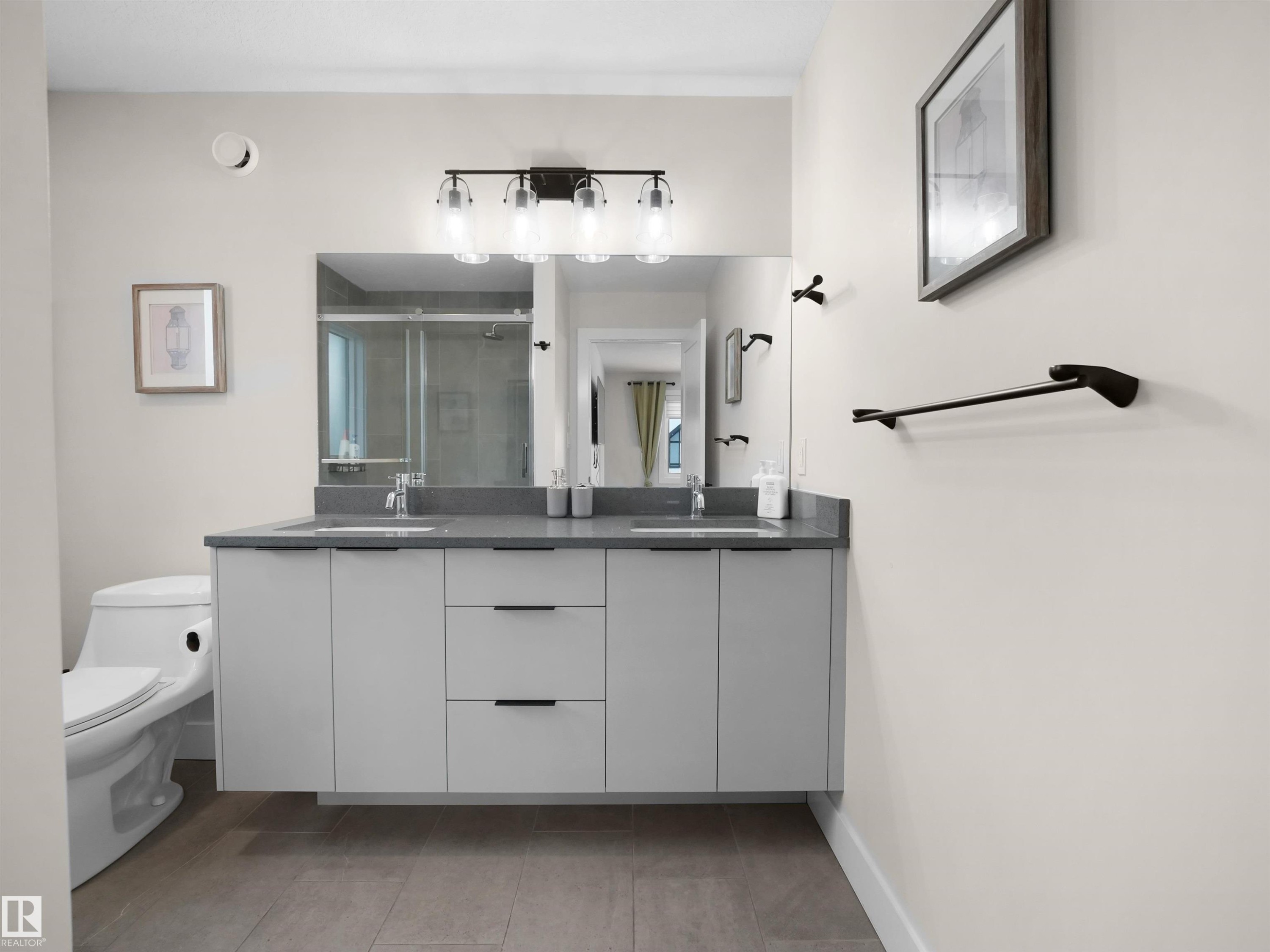 Floating dual vanity with a gray countertop, undermount sinks, and matte black fixtures - 20827 130 Avenue Nw, Edmonton, AB - Indoor Photo Showing Bathroom
