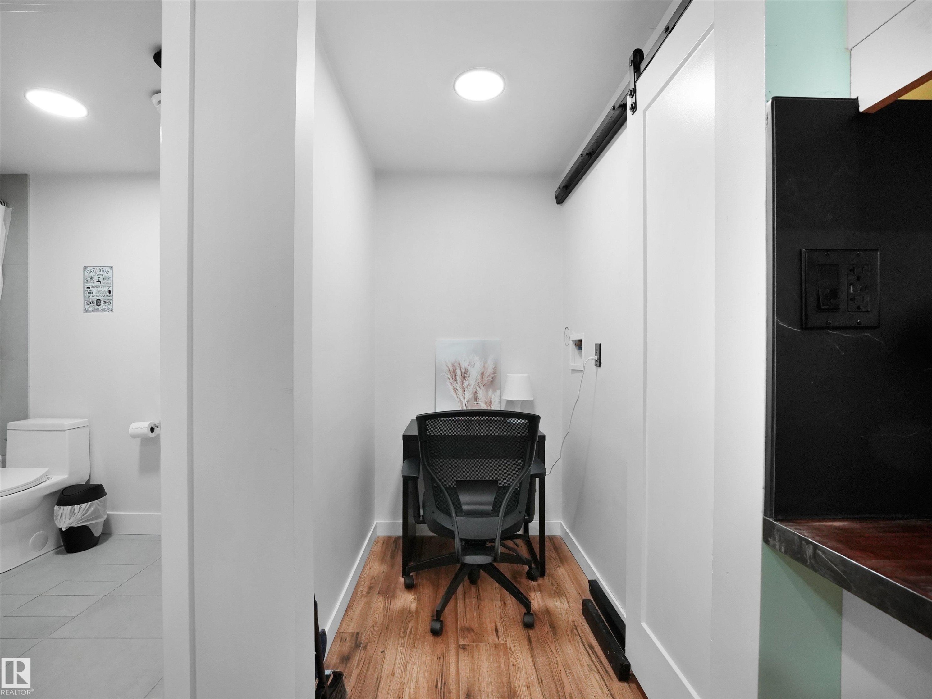Dedicated office nook featuring wood-finish flooring, recessed ceiling lighting, and a modern barn door - 20827 130 Avenue Nw, Edmonton, AB - Indoor Photo Showing Bathroom