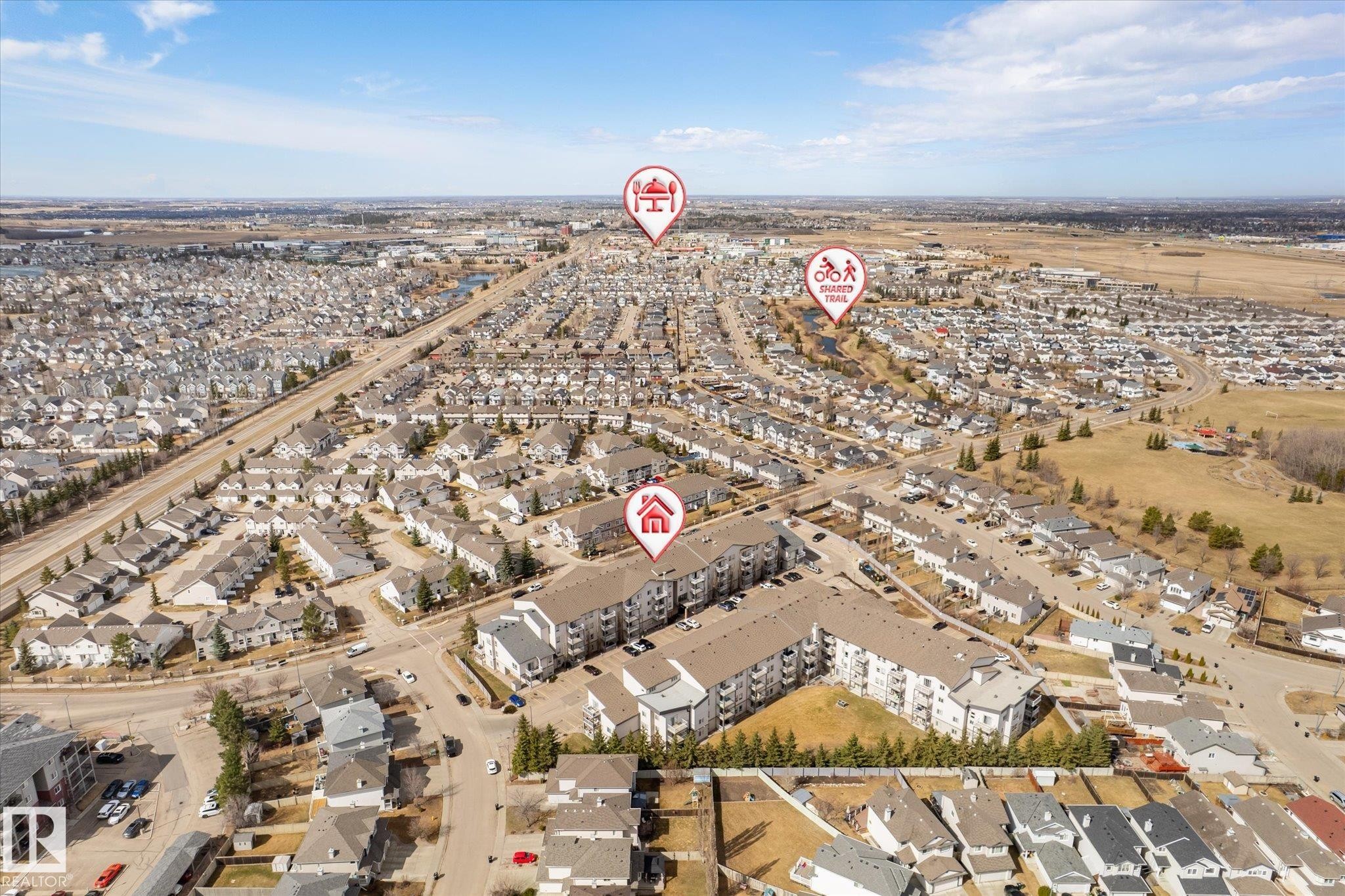 Expansive aerial view showcasing a dense residential community with varied housing styles - 203 155 Edwards Drive, Edmonton, AB - Outdoor With View