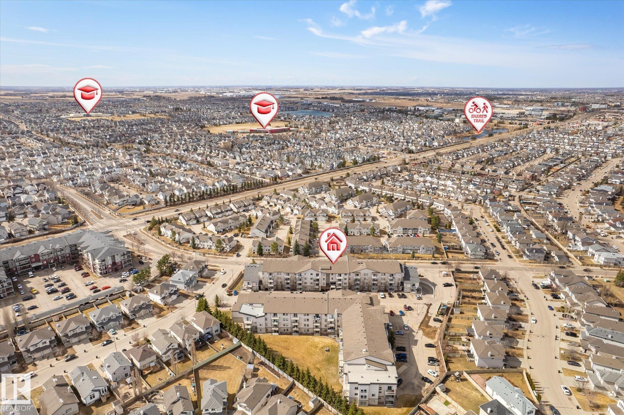 Aerial perspective of a developed residential area with numerous detached homes and multi-story apartment buildings - 203 155 Edwards Drive, Edmonton, AB - Outdoor With View