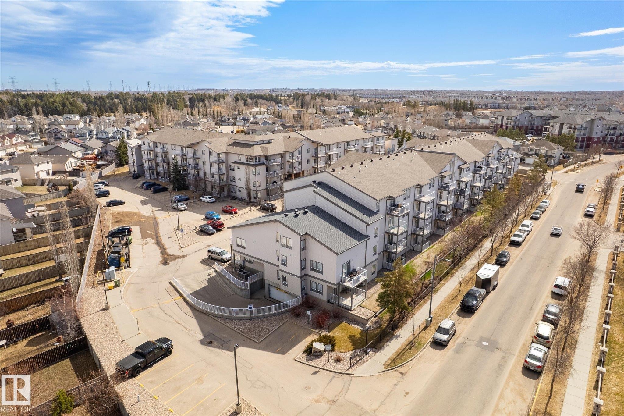 Aerial perspective showcasing a multi-story residential building with private balconies and a neutral exterior color palette - 203 155 Edwards Drive, Edmonton, AB - Outdoor With View
