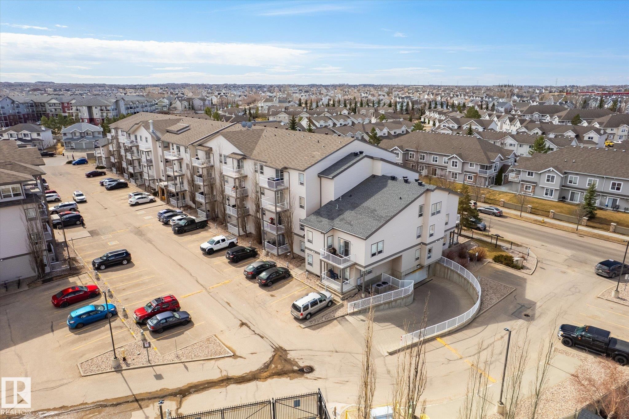 Multi-story residential building with private balconies and a neutral exterior palette - 203 155 Edwards Drive, Edmonton, AB - Outdoor With View
