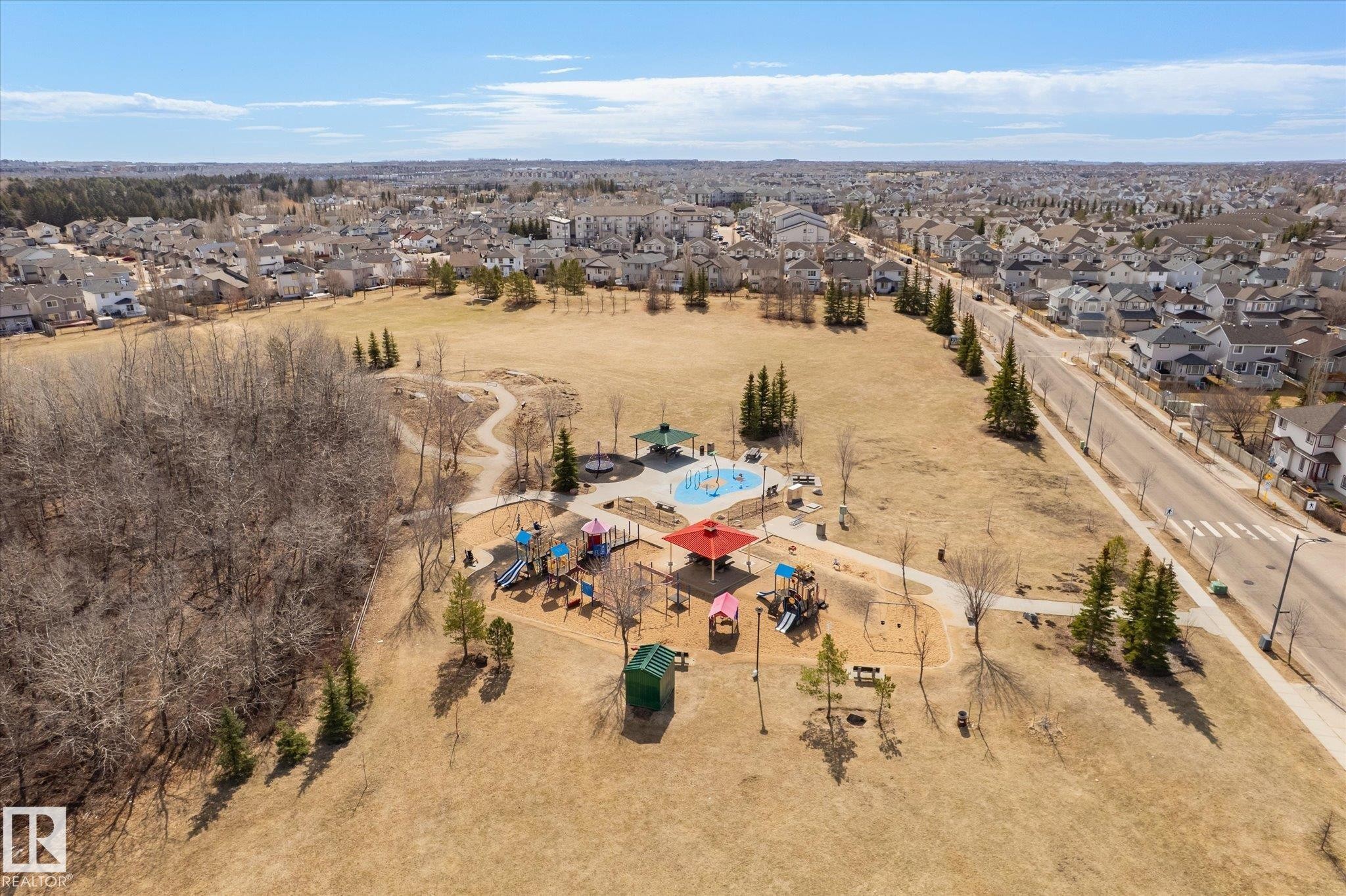 Community park featuring a playground, splash pad, and walking paths - 203 155 Edwards Drive, Edmonton, AB - Outdoor With View