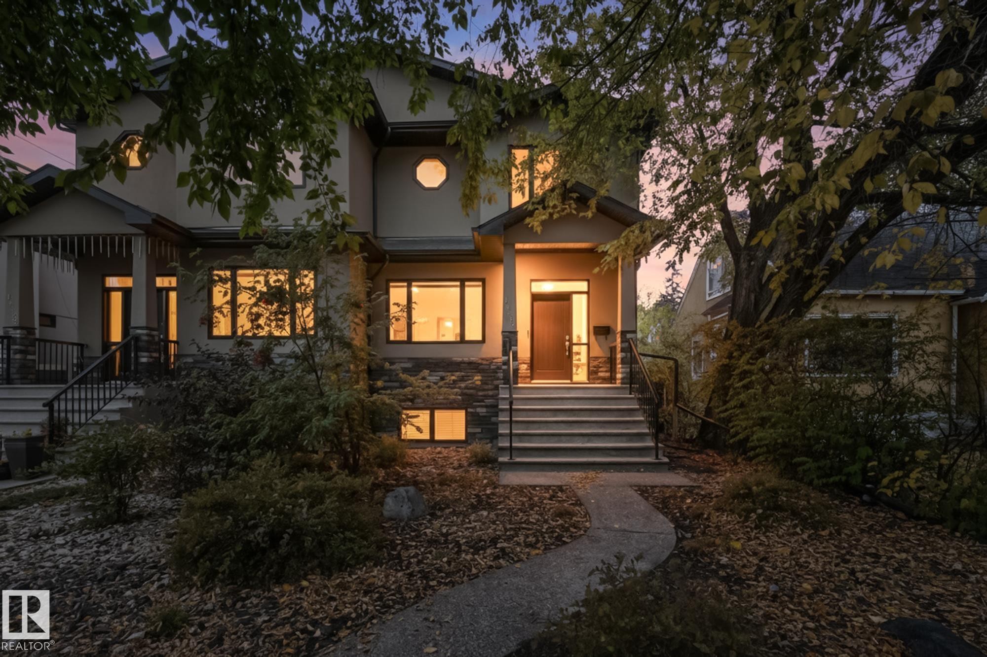 Stucco exterior with stone veneer accents, featuring a prominent front entrance with multiple steps and wrought iron railings - 11106 76 Avenue, Edmonton, AB - Outdoor