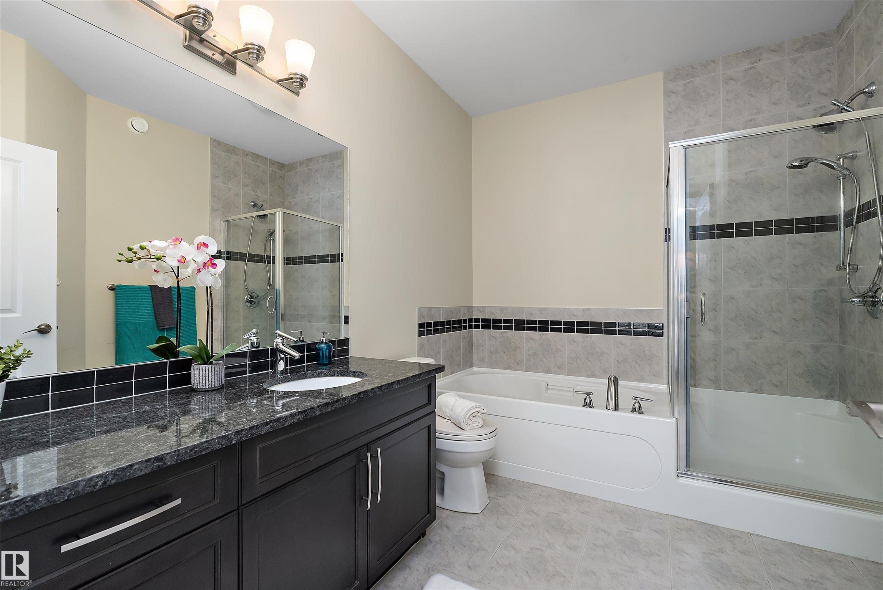 Bathroom featuring a dark wood vanity with a granite countertop, undermount sink, and polished chrome fixtures - 14 3090 Cameron Heights Way, Edmonton, AB - Indoor Photo Showing Bathroom